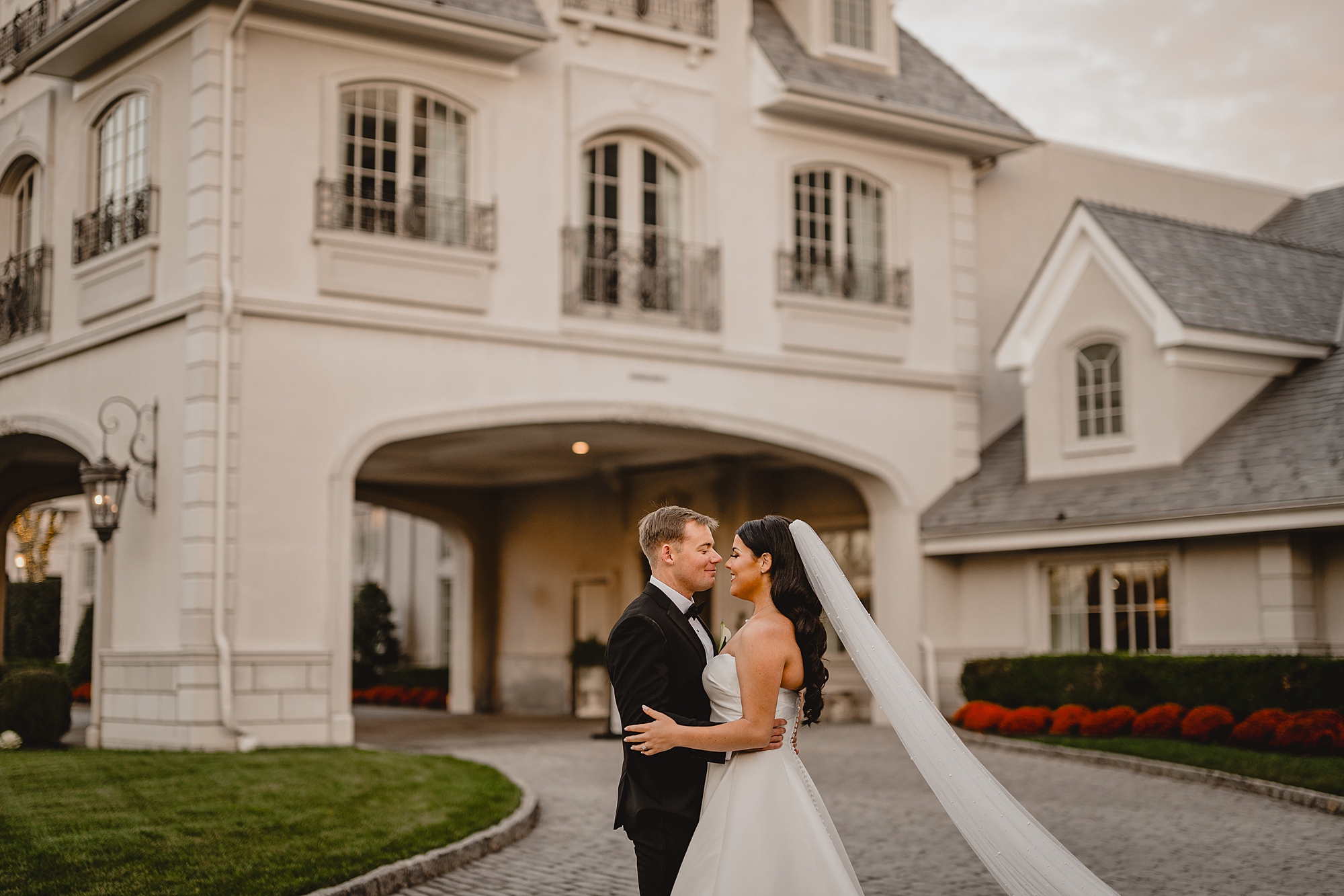 newlyweds hug on driveway in New Jersey at Park Chateau