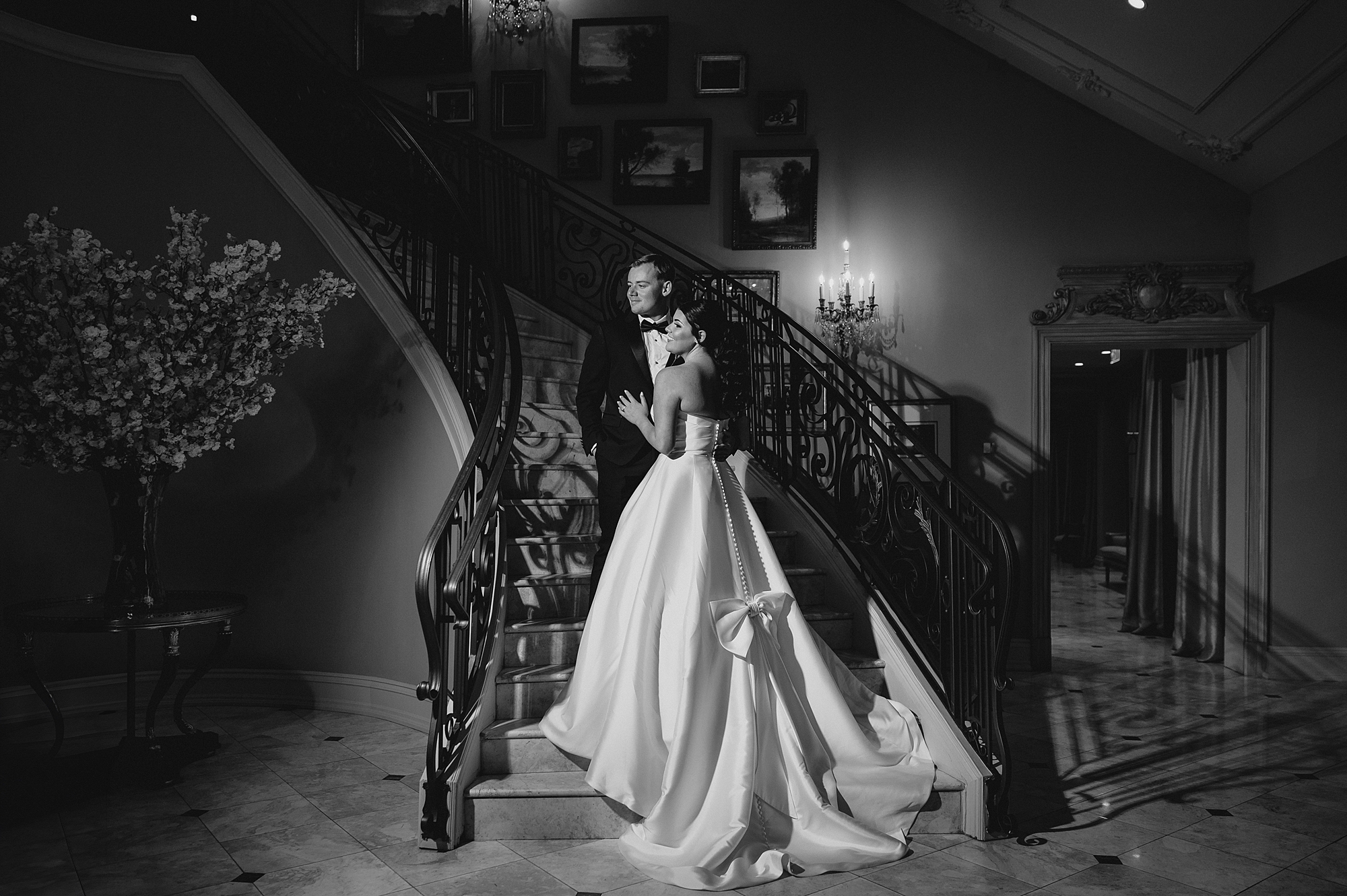 bride hugs groom standing on steps inside Park Chateau Estate 
