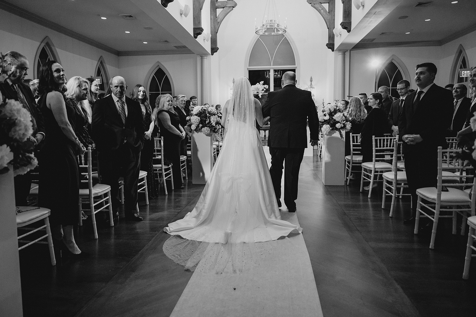father escorts bride down aisle for ceremony in Park Chateau chapel