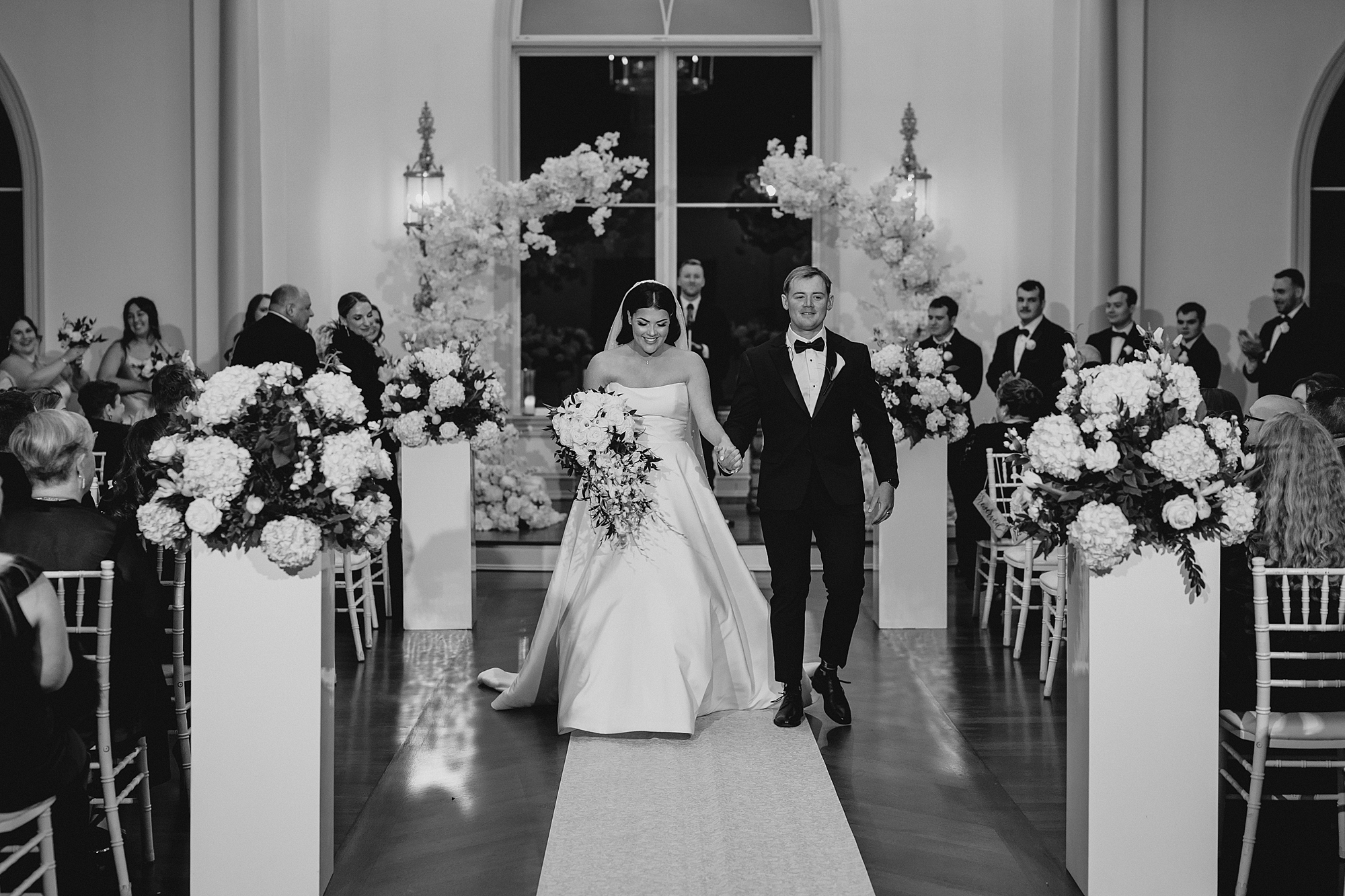 bride and groom hold hands leaving ceremony at Park Chateau chapel