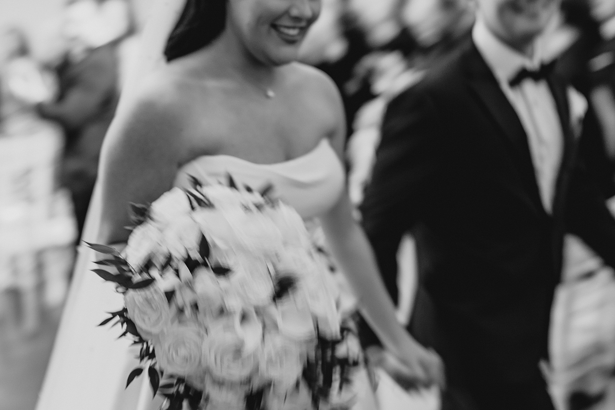 bride and groom hold hands in blurry photo leaving ceremony at Park Chateau chapel