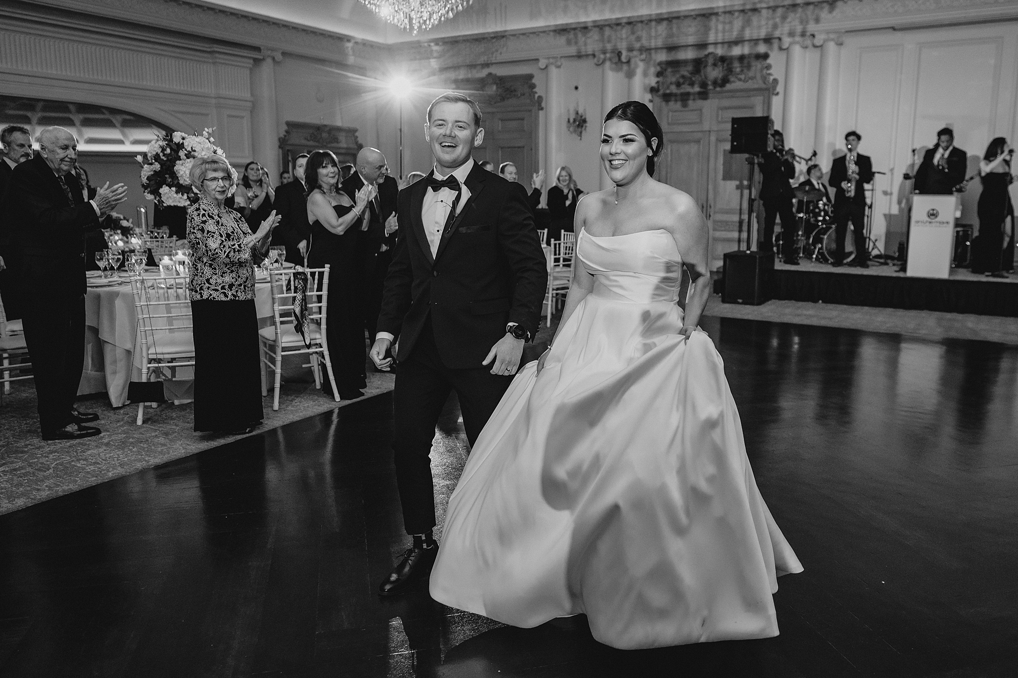 newlyweds laugh walking onto dance floor at Park Chateau Estate