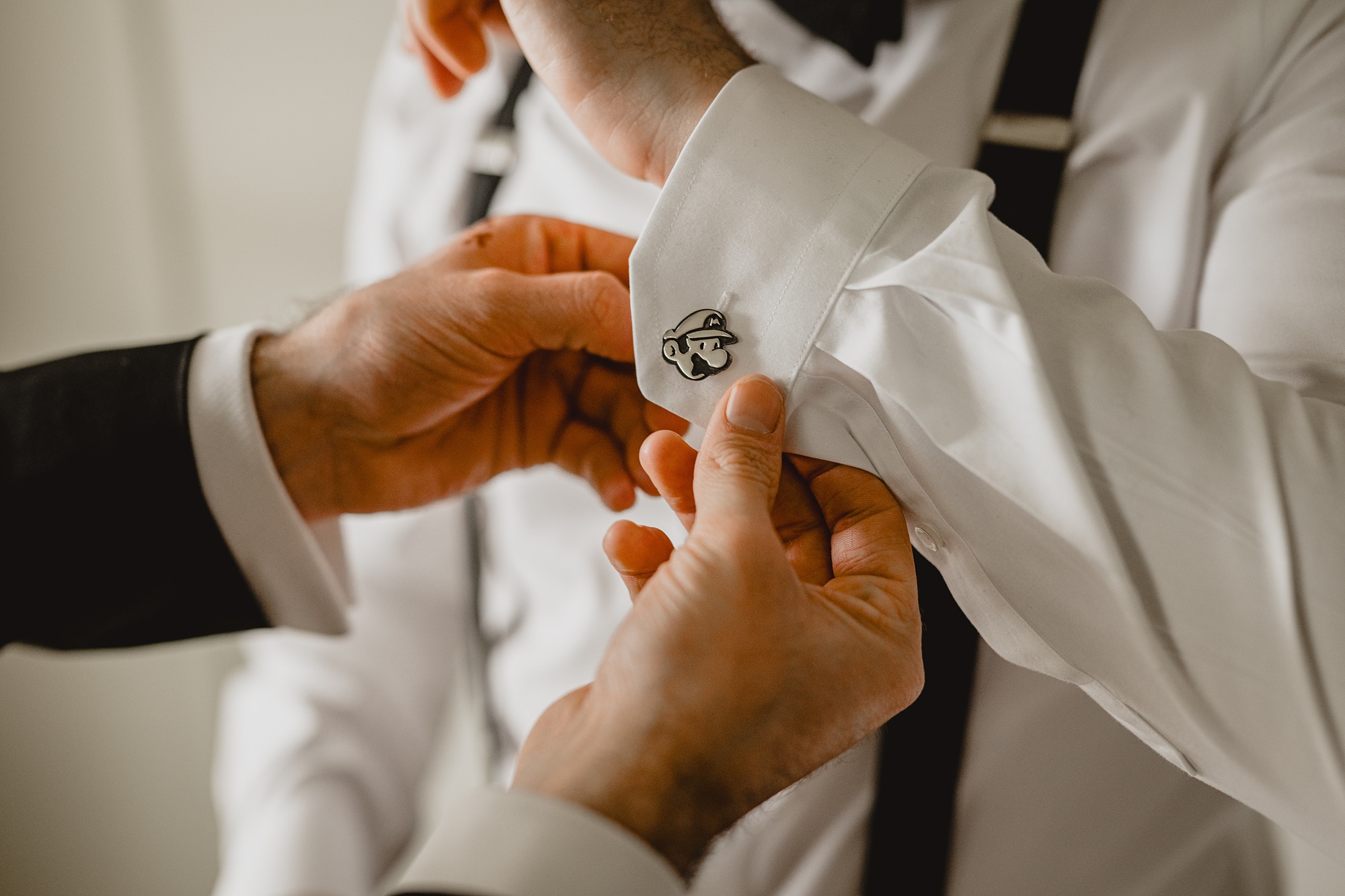 groom shows off custom cufflinks for wedding at the Lake House at Canandaigua