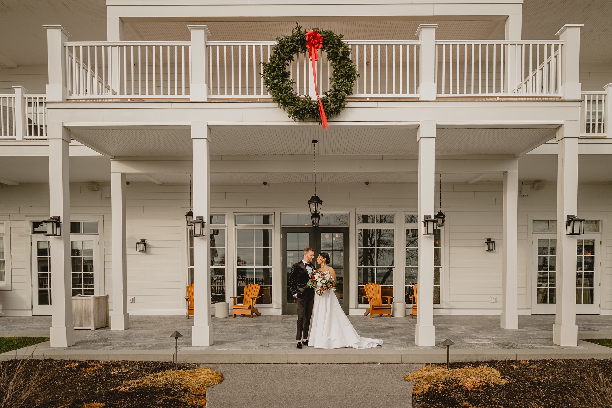 bride and groom stand on front porch of the Lake House at Canandaigua