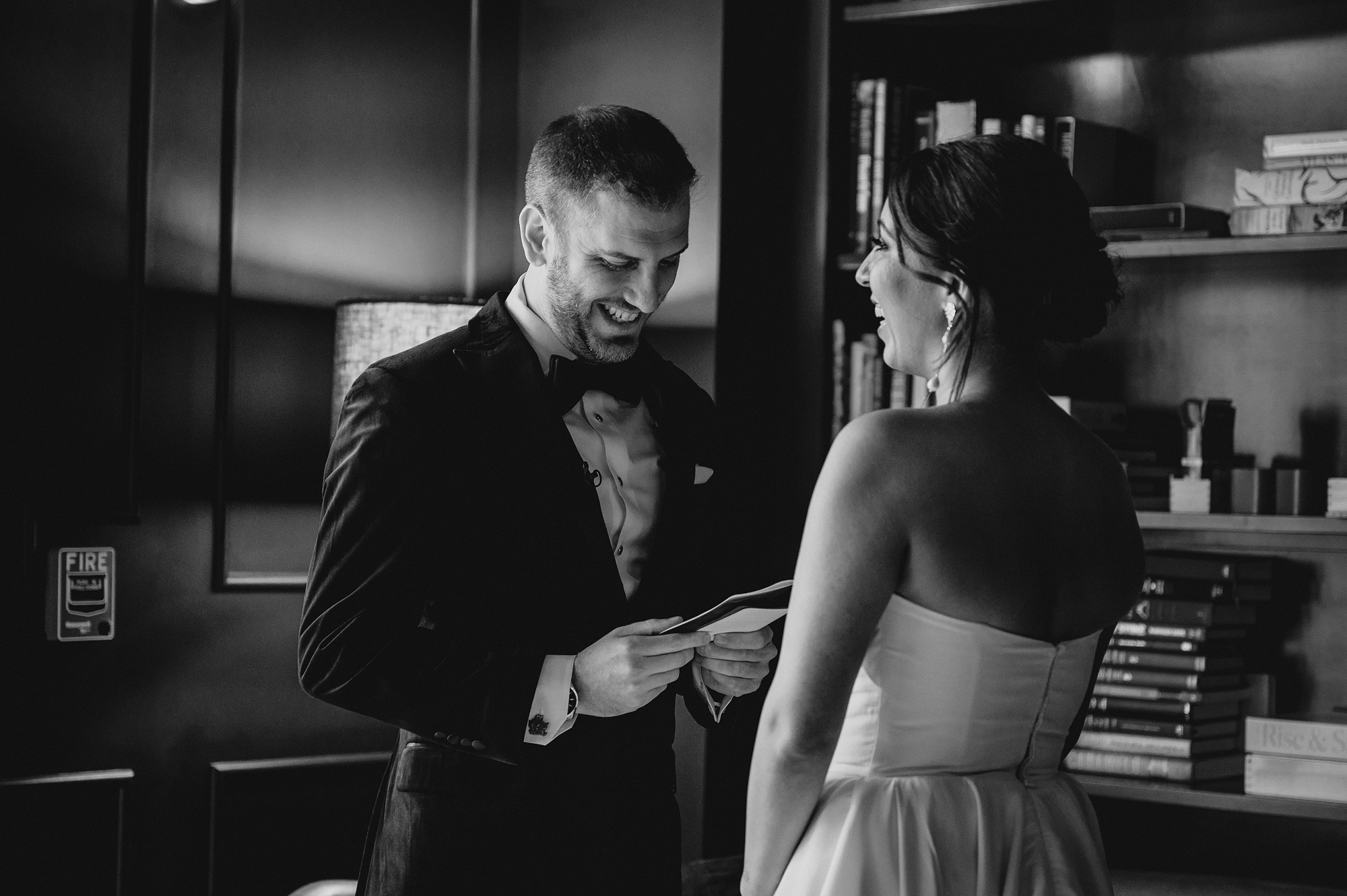bride and groom read vows in library at the Lake House at Canandaigua