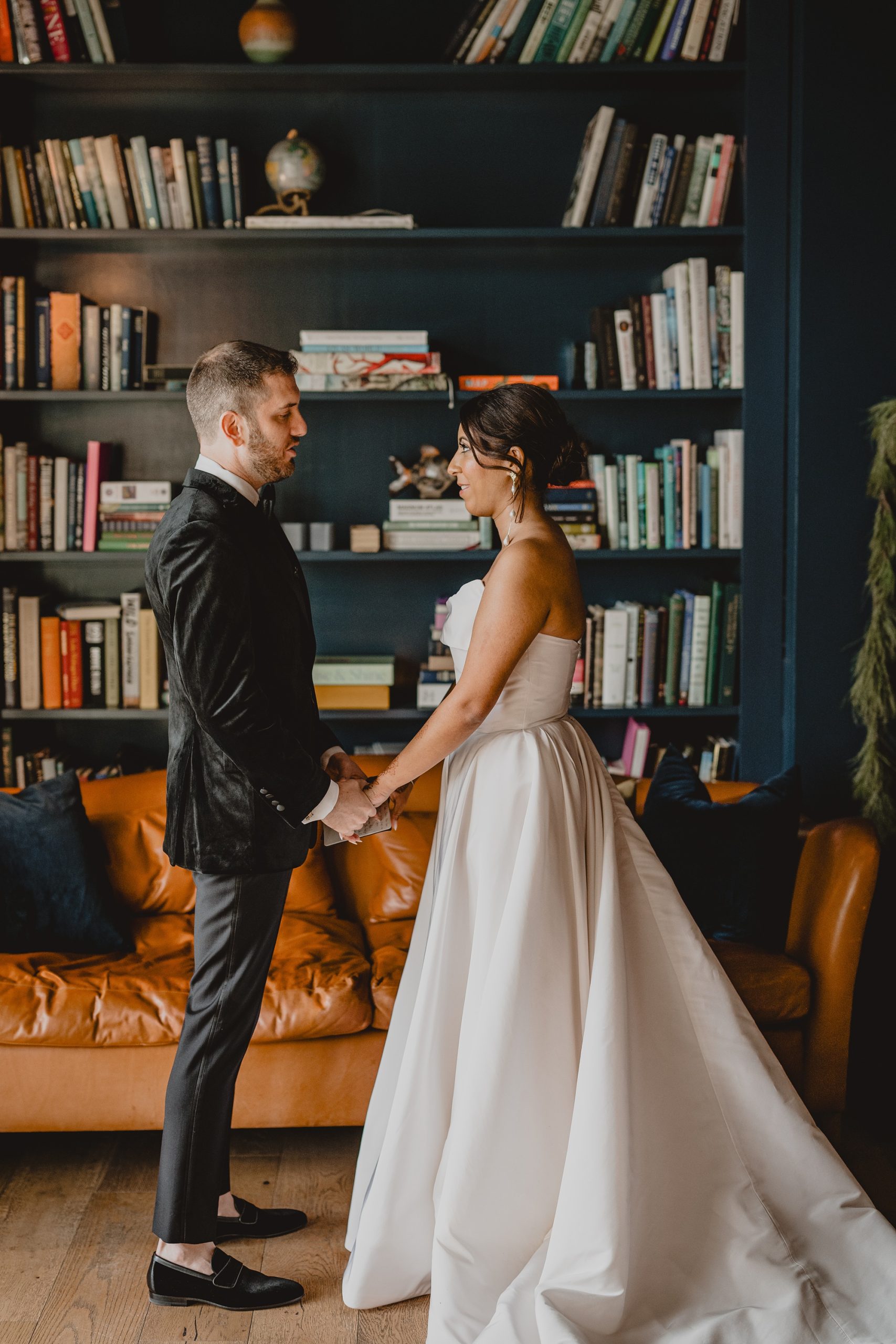 bride and groom read vows in library at the Lake House at Canandaigua
