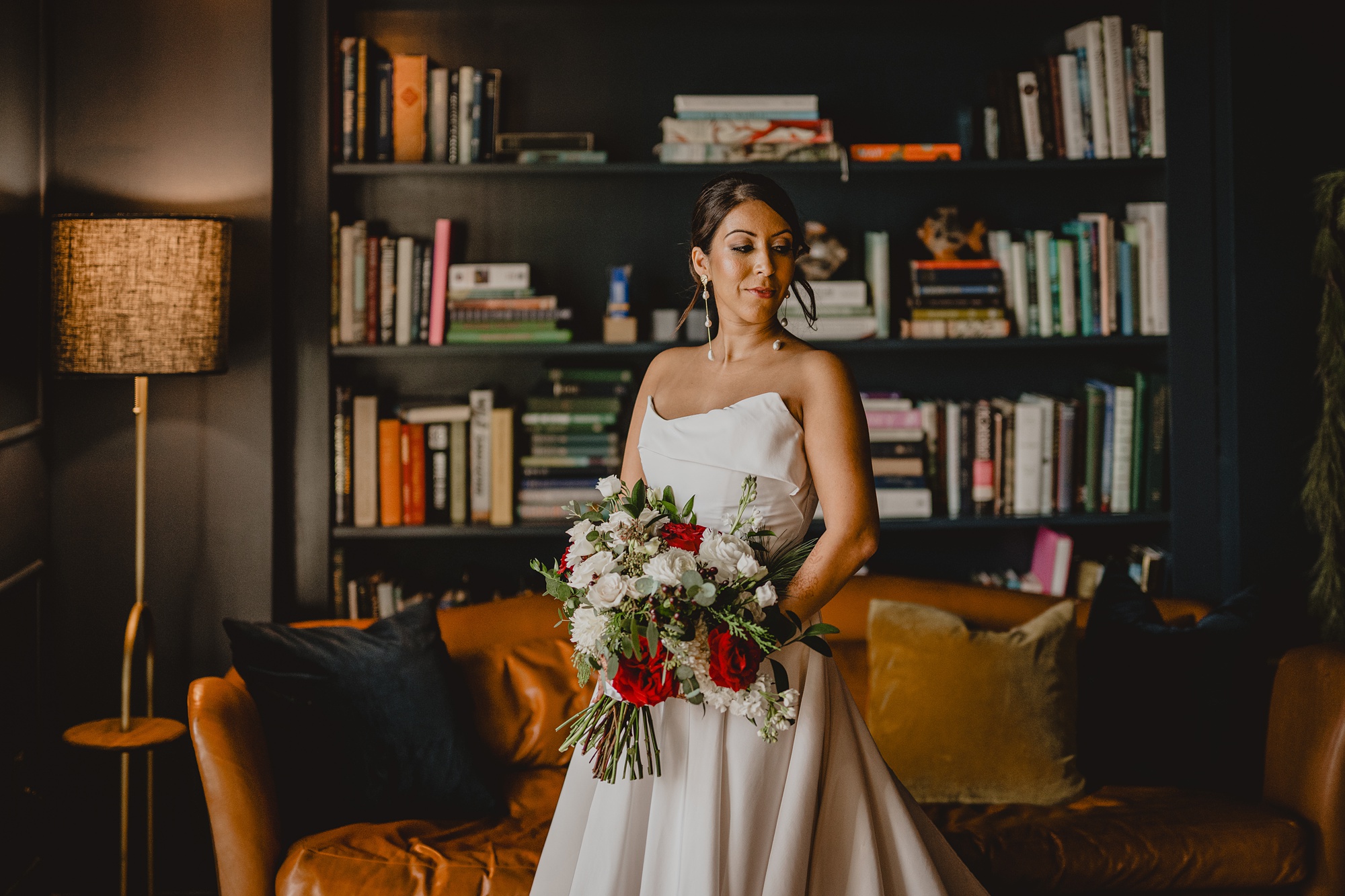 bride holds bouquet of flowers in library at the Lake House at Canandaigua