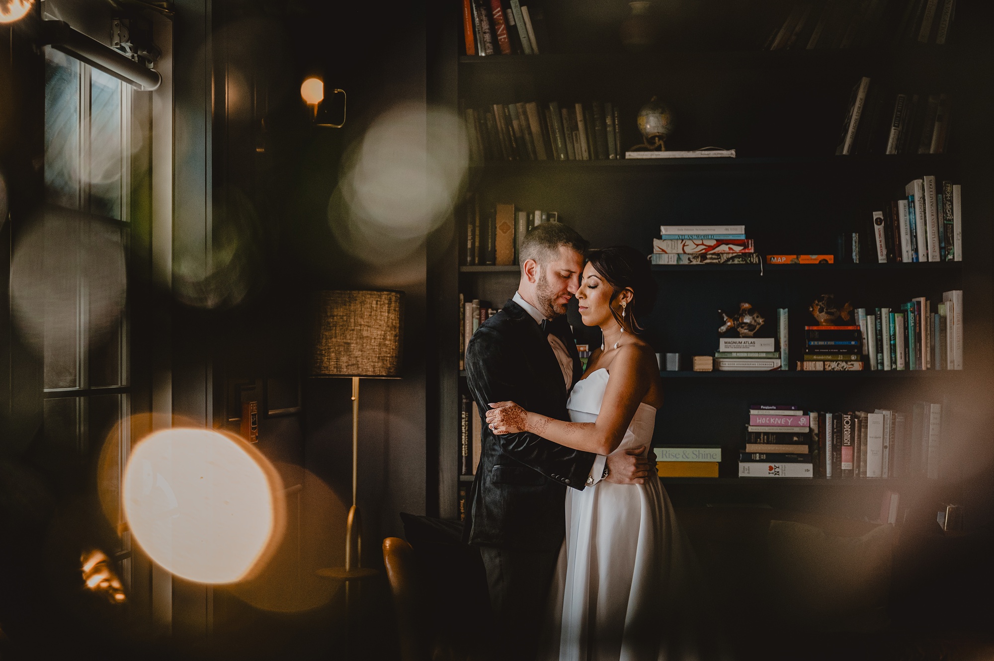newlyweds hug in library at the Lake House at Canandaigua