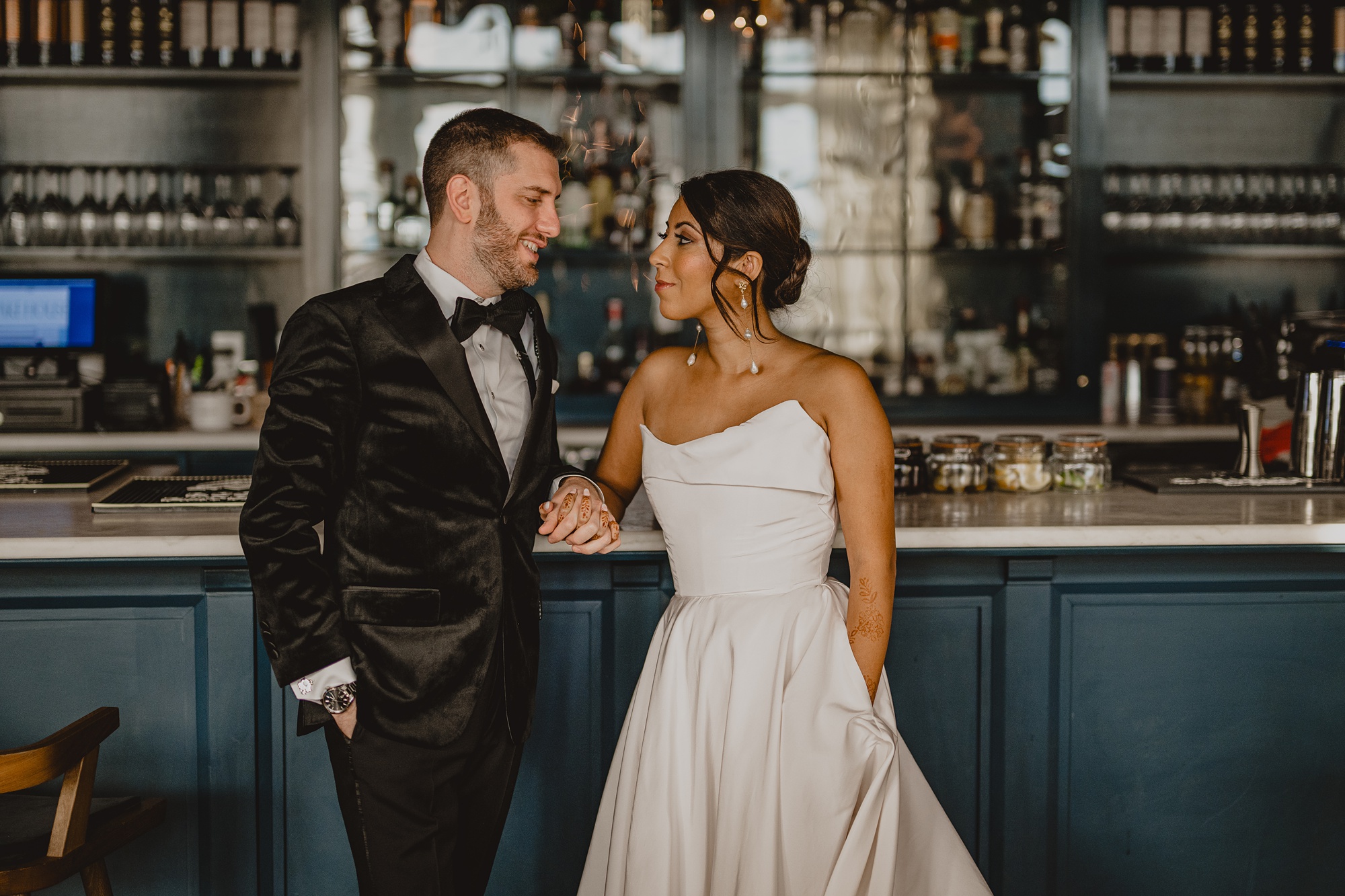 bride and groom lean against bar at the Lake House at Canandaigua