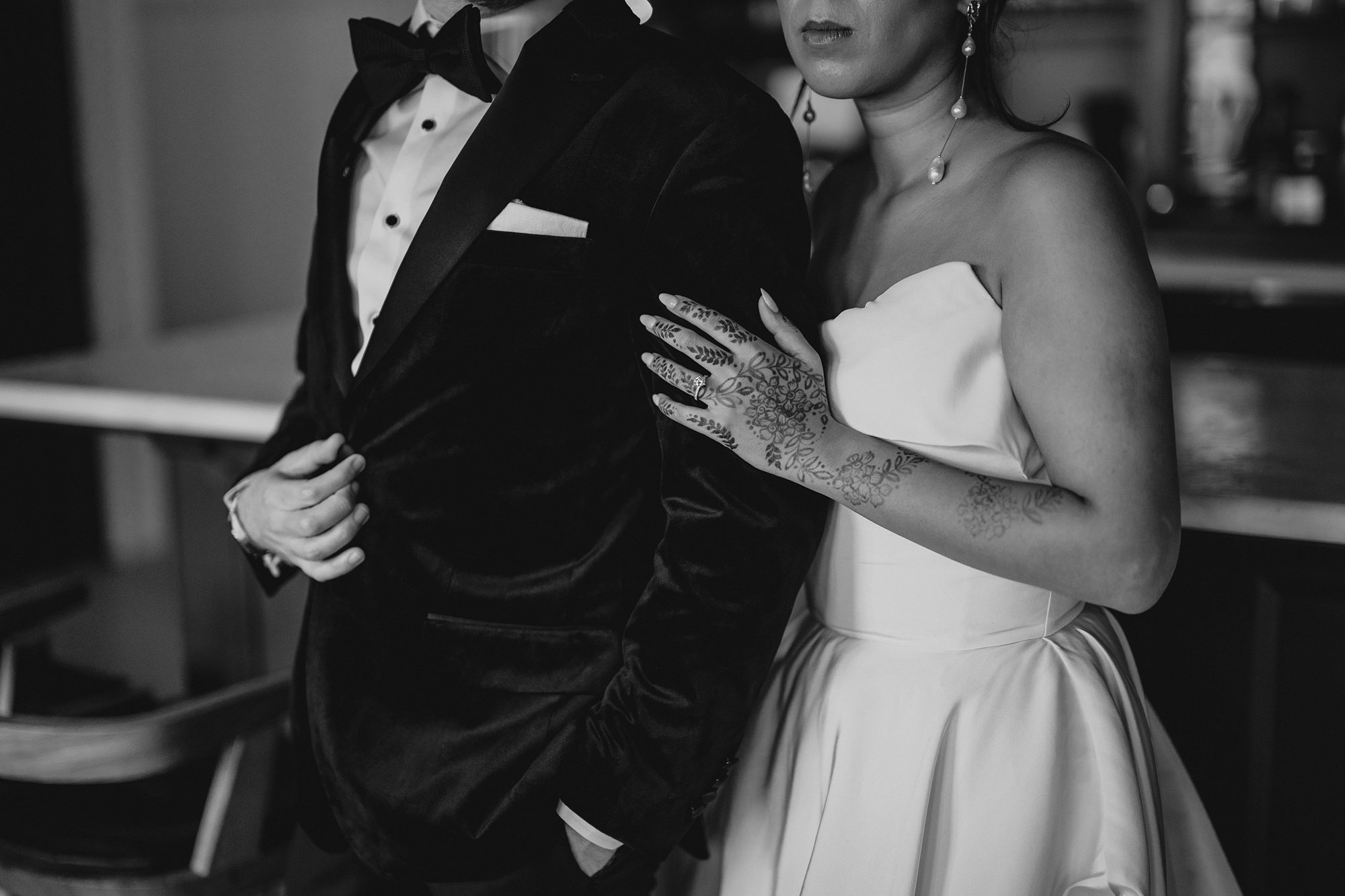 bride in strapless gown holds groom's arm in black tux 