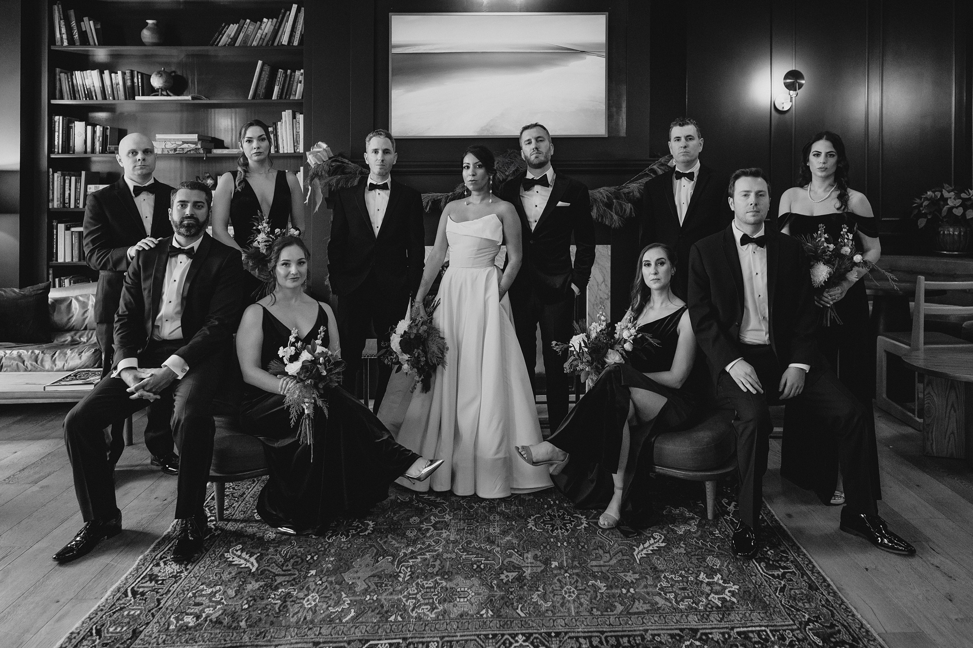 newlyweds pose with wedding party in a library 