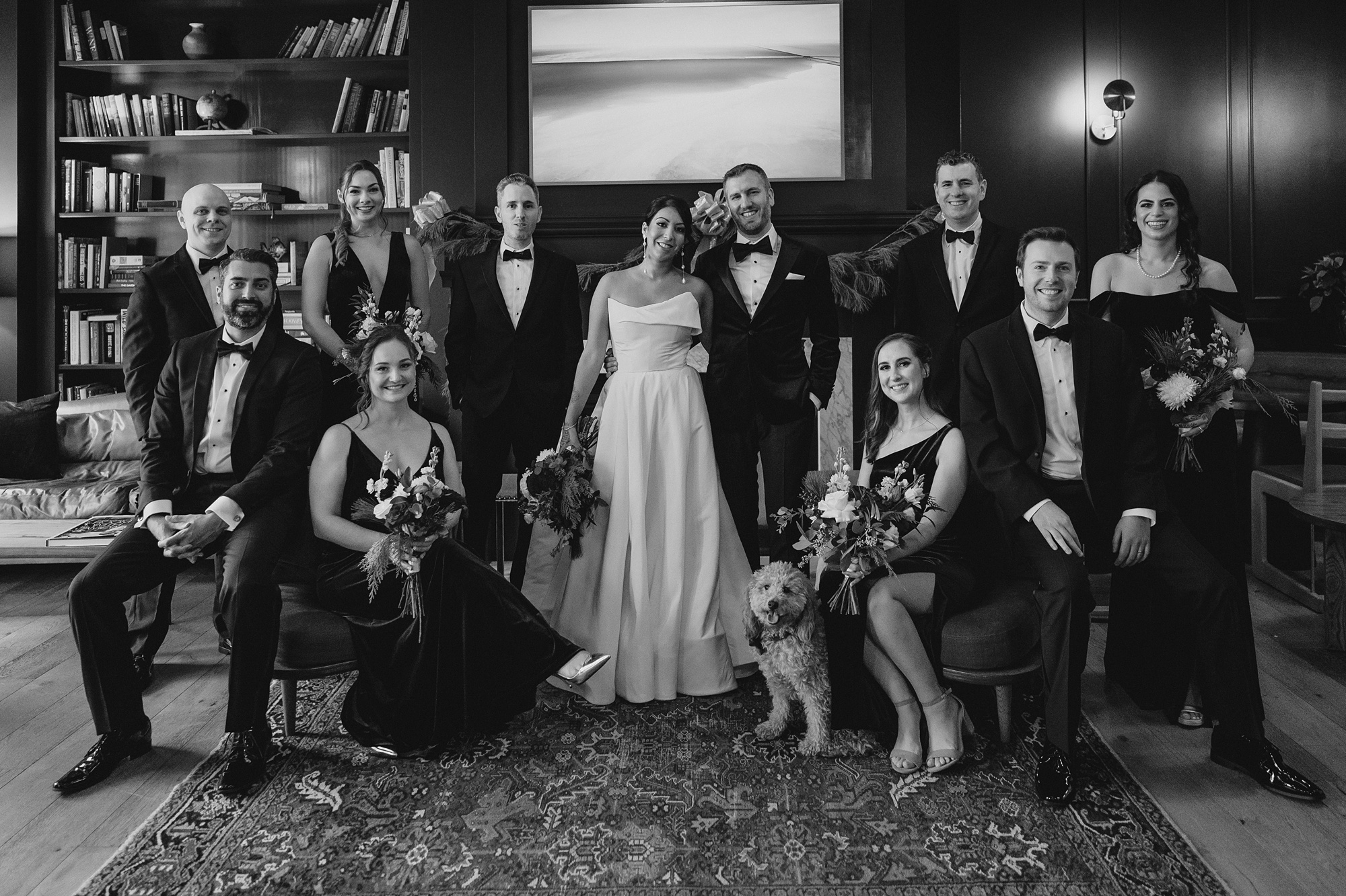 bride and groom stand surrounded by wedding party at the Lake House at Canandaigua