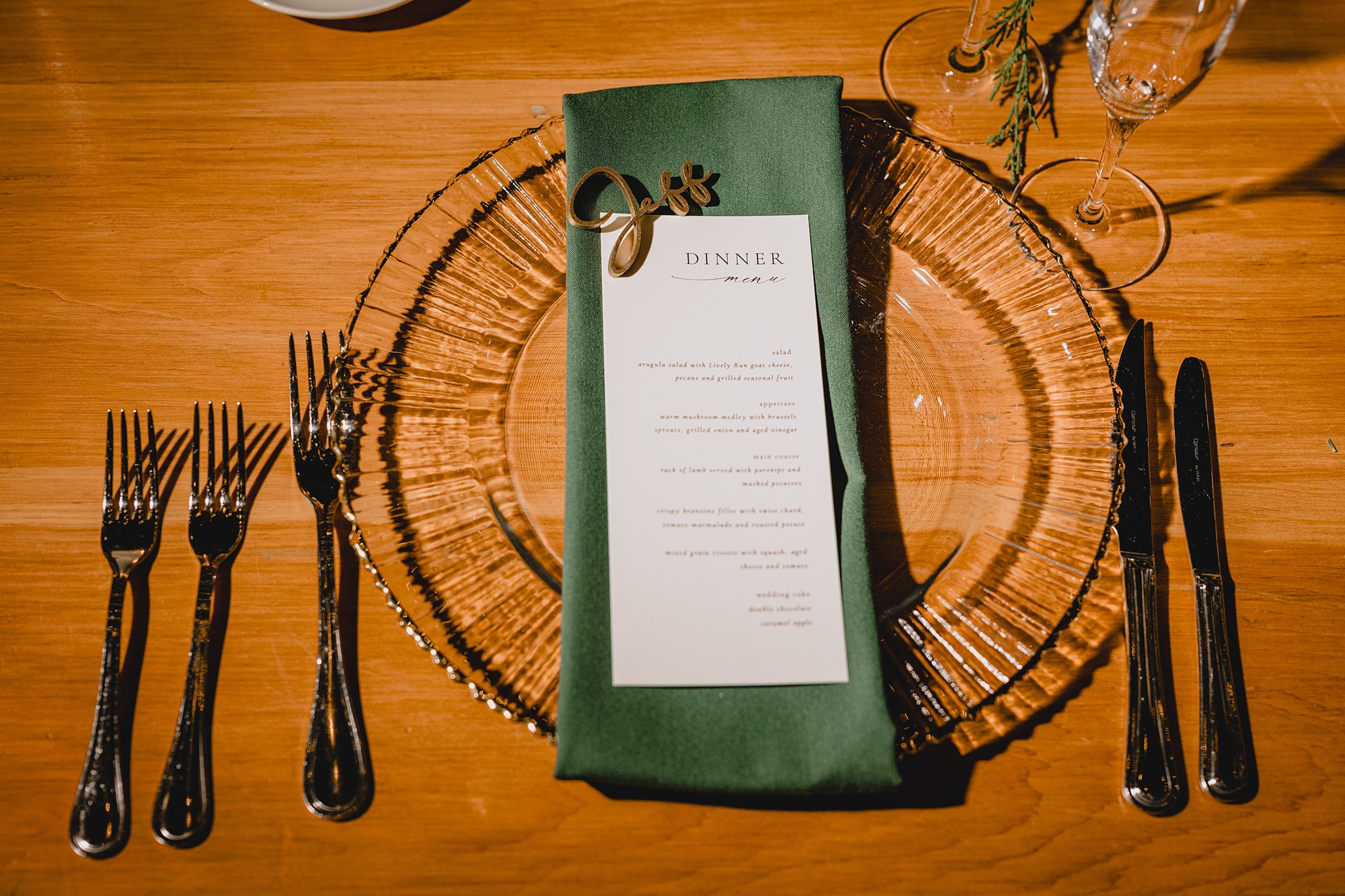 glass plate with green napkin and wooden name piece 