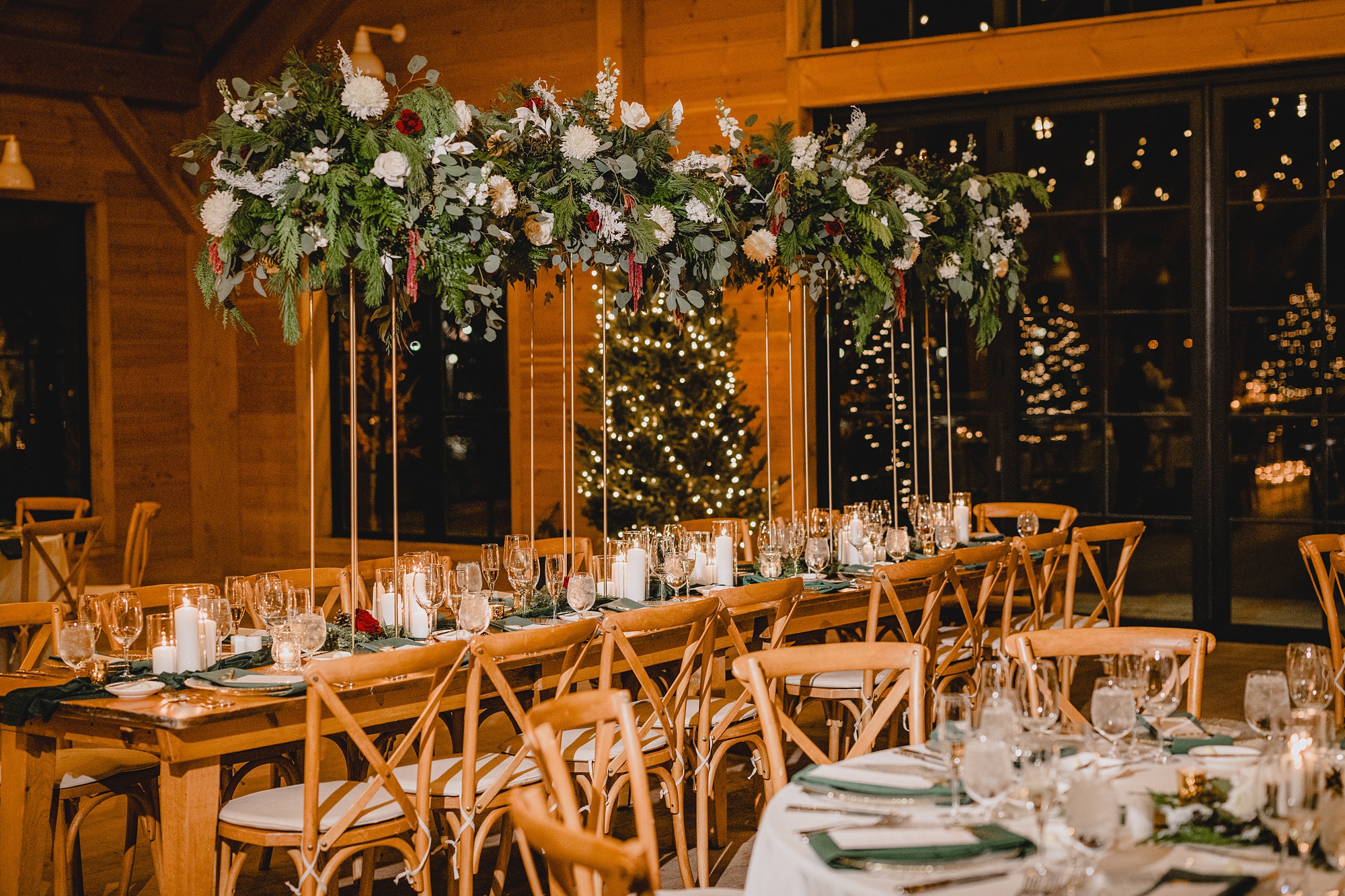 winter wedding reception at the Lake House at Canandaigua with wooden tables, candles, and greenery with pinecones down table 