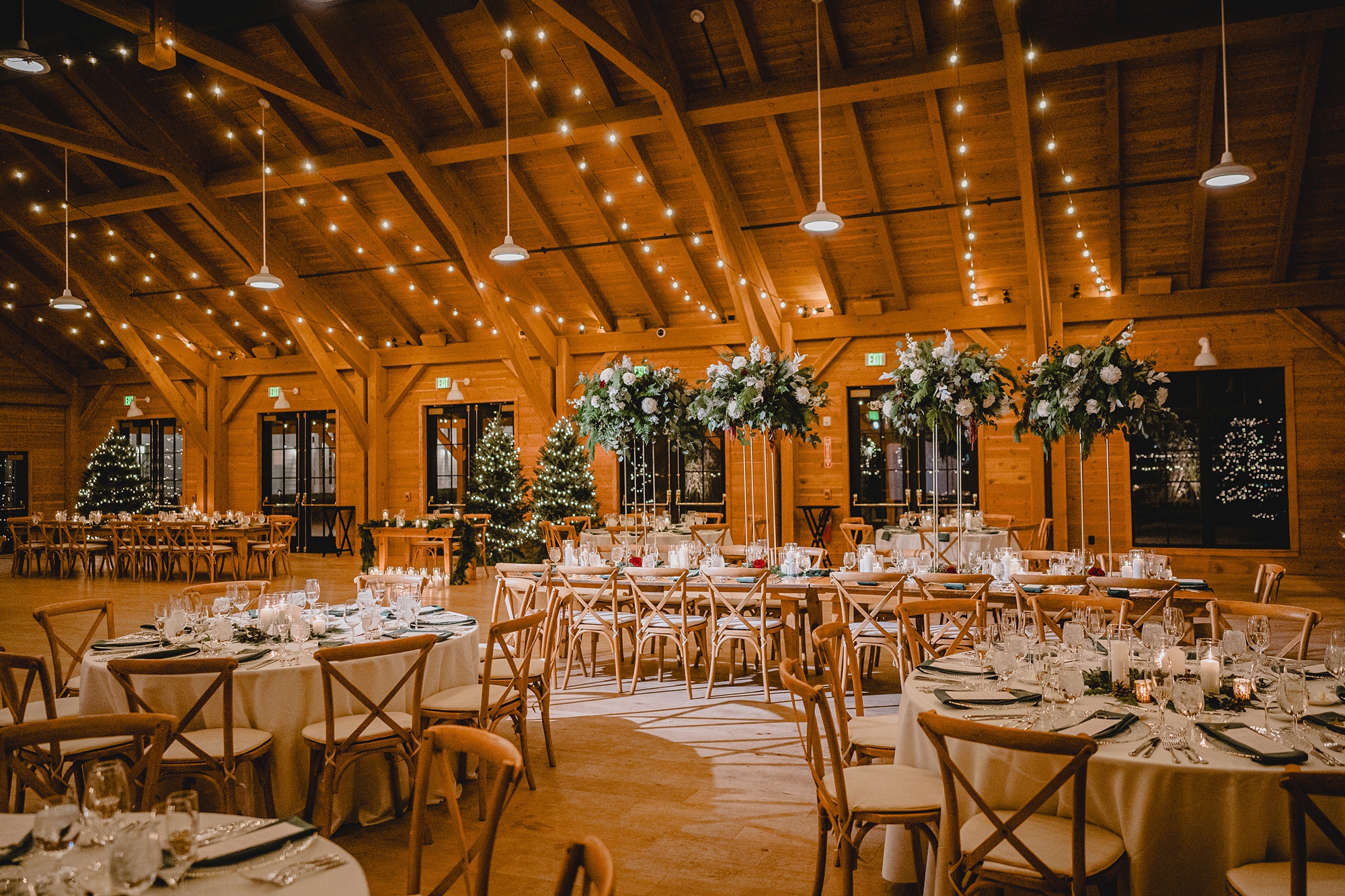 wedding reception at the Lake House at Canandaigua with wooden furniture, greenery and pinecones on table 