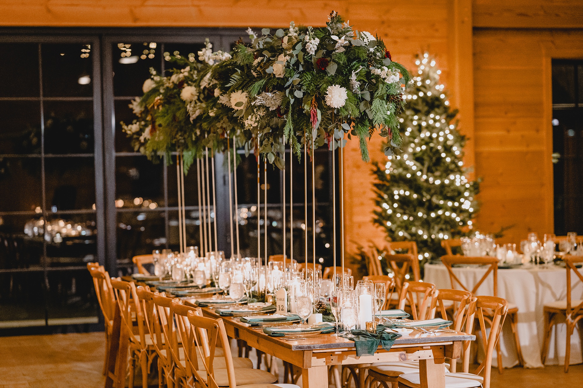 wooden tables with tall greenery centerpieces at the Lake House at Canandaigua