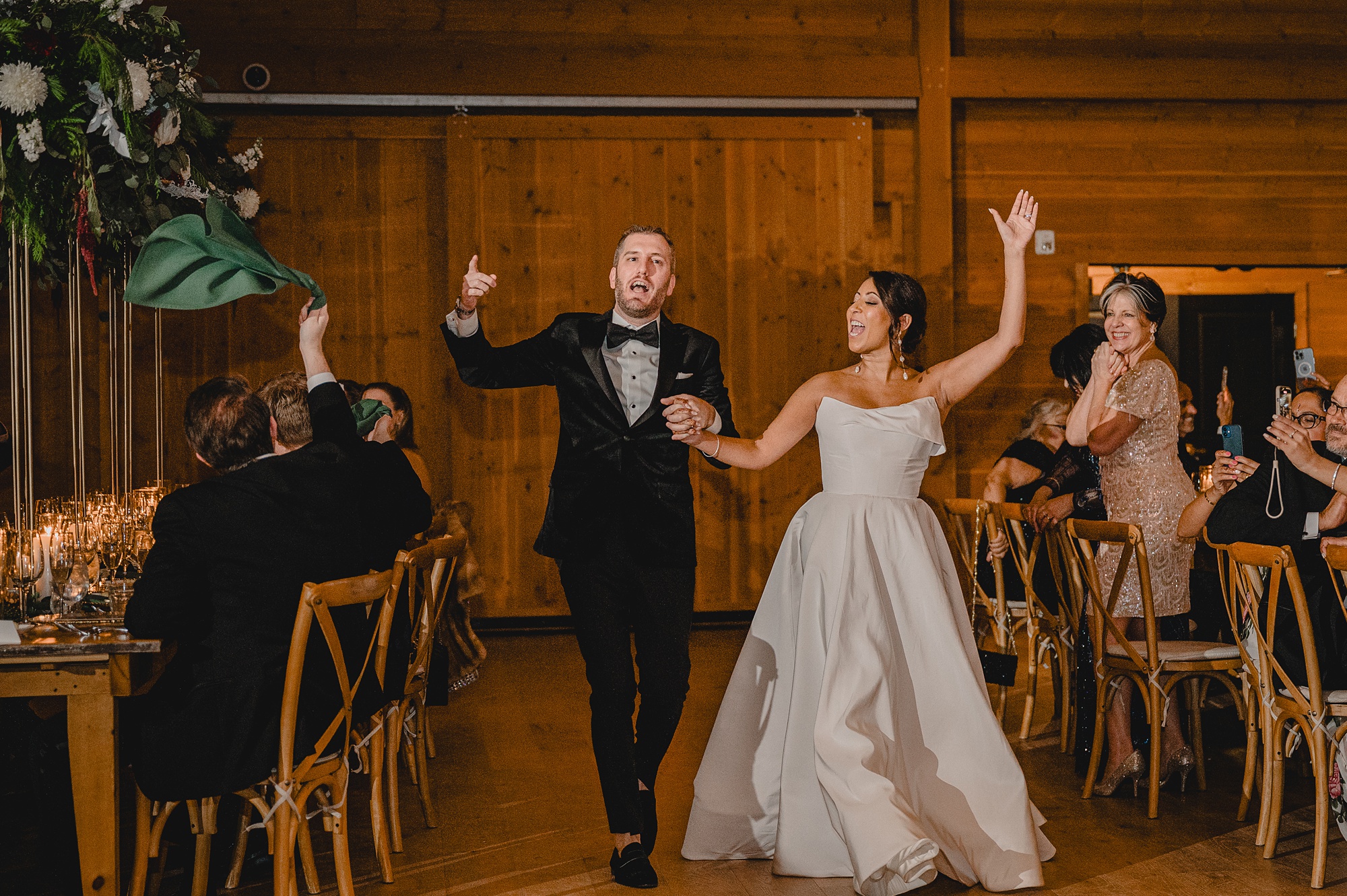 bride and groom cheer walking into wedding reception at the Lake House at Canandaigua