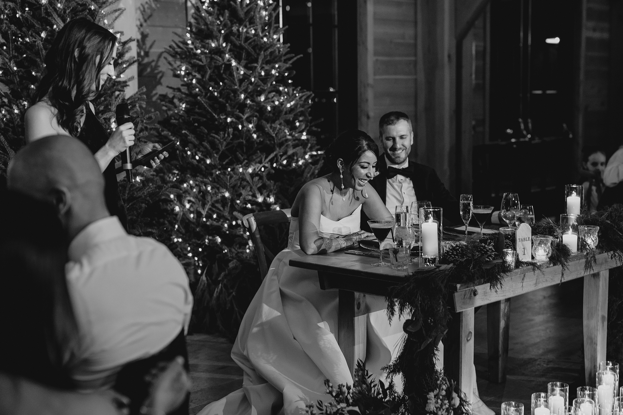 bride and groom laugh sitting at sweetheart table during winter wedding reception in New Jersey