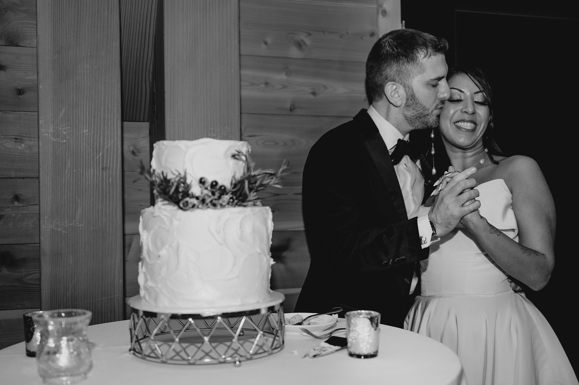 groom kisses bride's cheek during winter wedding reception in New Jersey