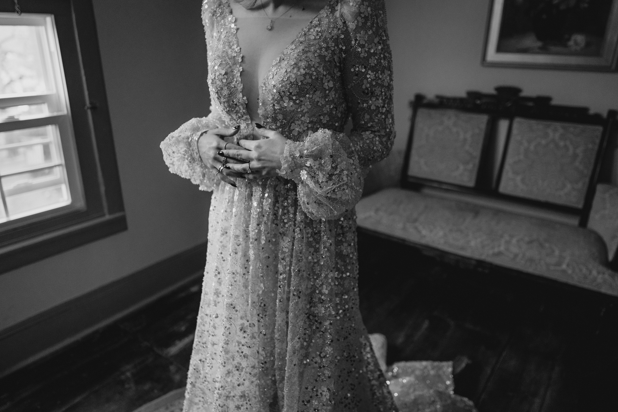 bride stands in long sleeve wedding gown