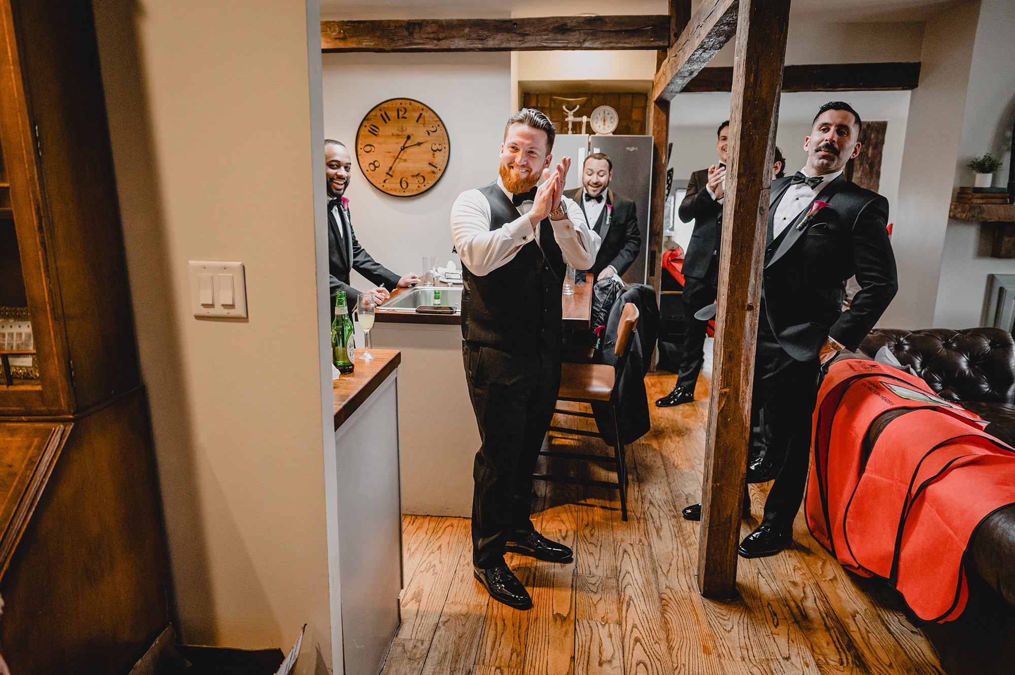 groom laughs clapping his hands together with groomsmen