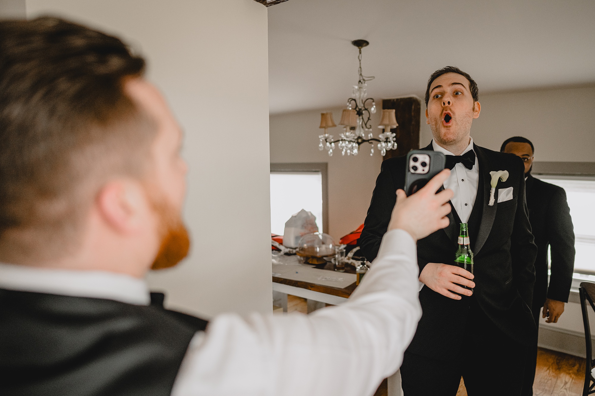 groom reacts to seeing something on groomsman's phone