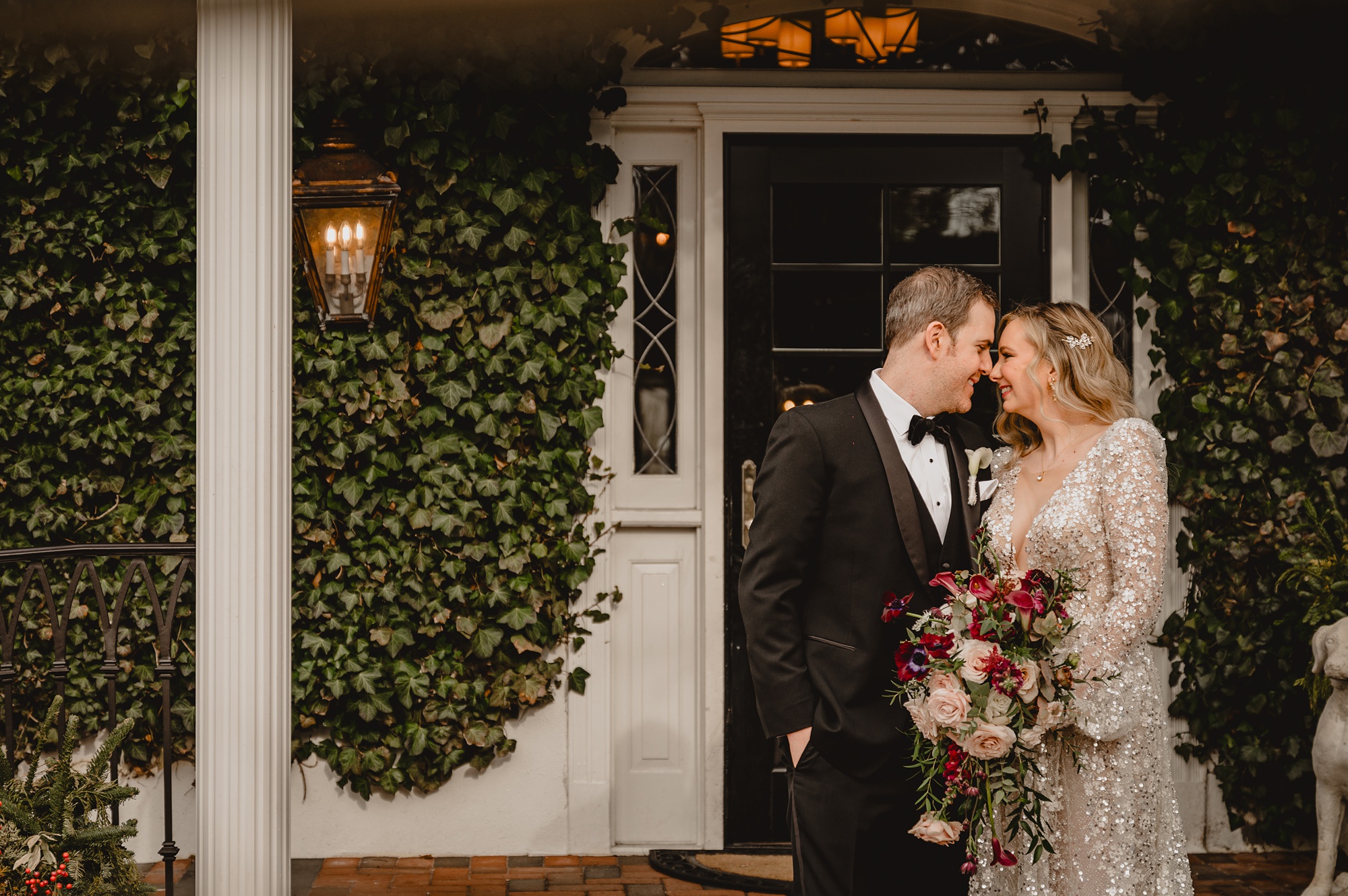 bride and groom lean heads together by back door at David's Country Inn