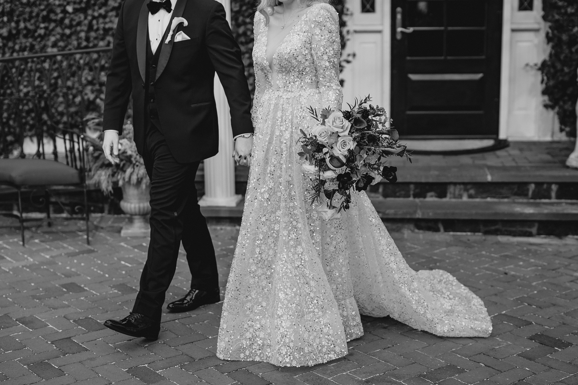 bride and groom hold hands walking on patio at David's Country Inn