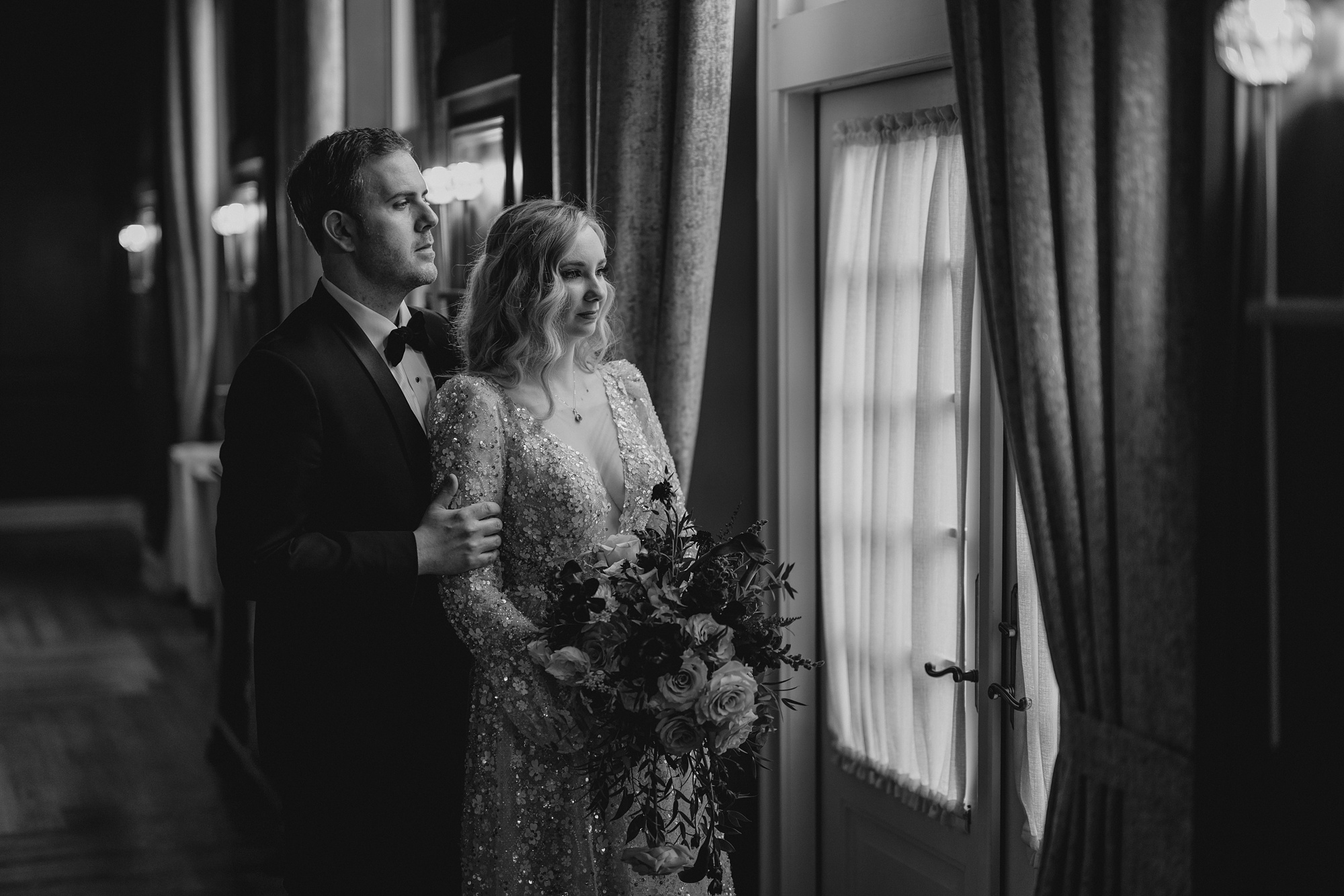 newlyweds stand looking out window from inside David's Country Inn
