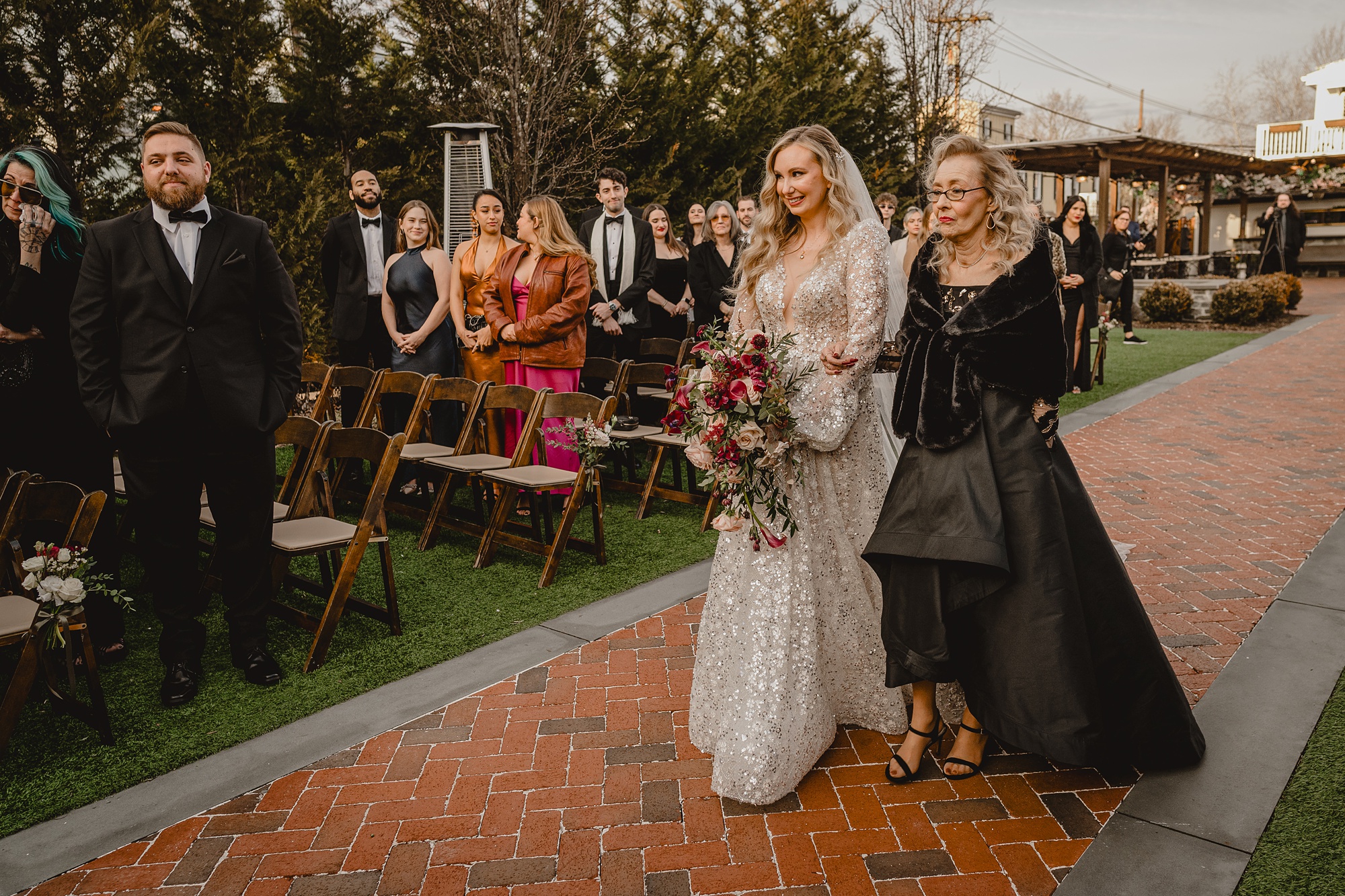 bride and mother walk down aisle for outdoor ceremony