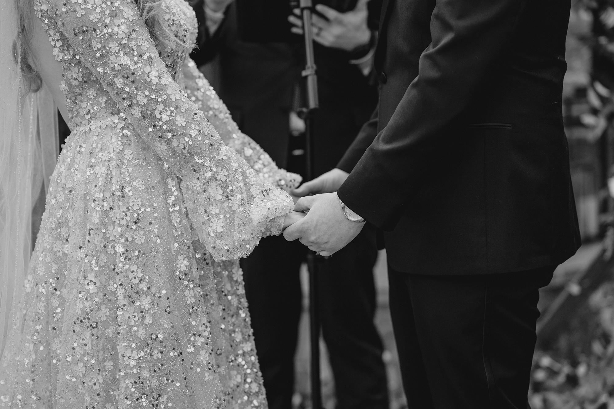 newlyweds hold hands during winter wedding ceremony outside at David's Country Inn