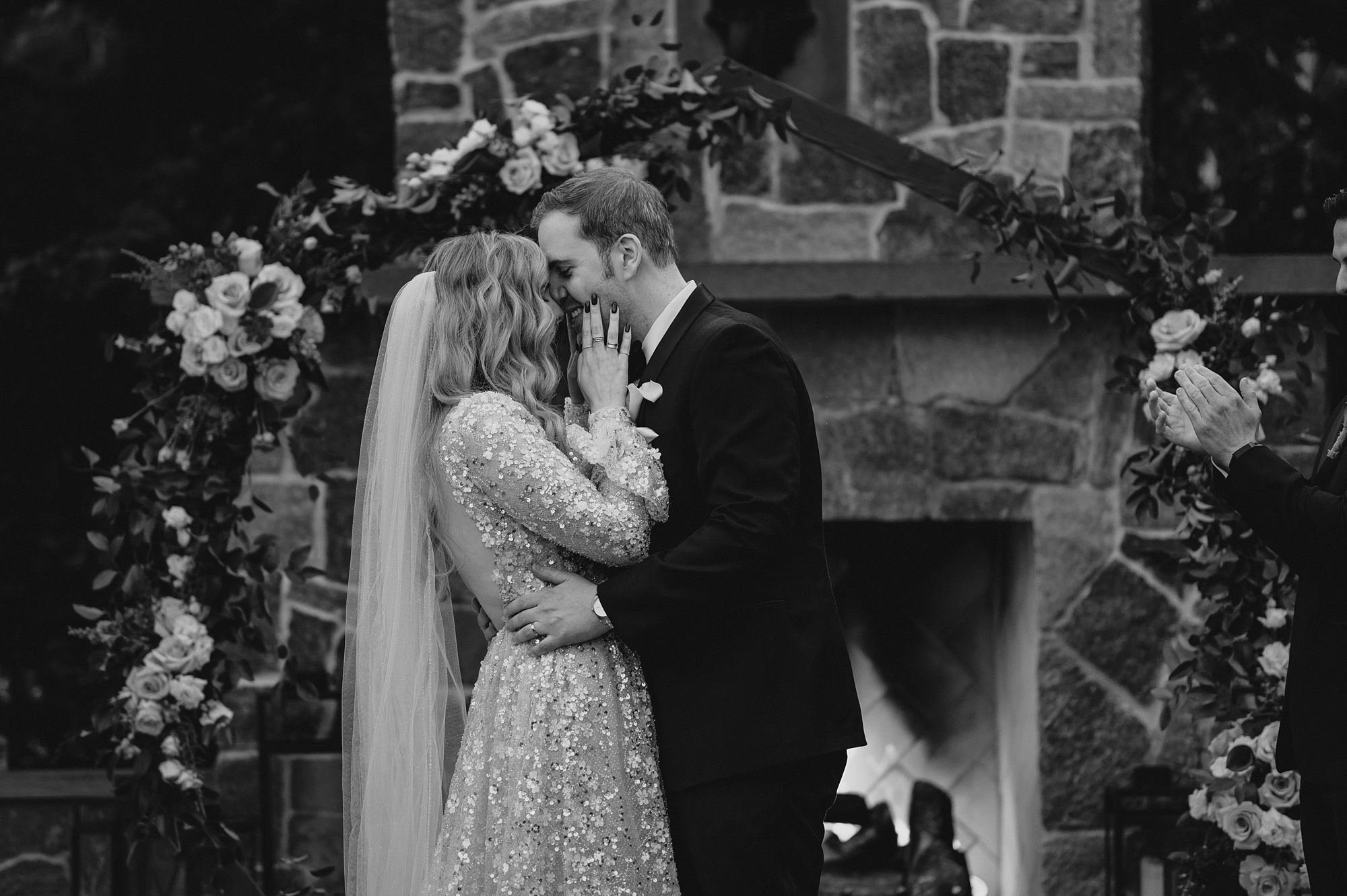bride and groom kiss by stone fireplace after David's Country Inn