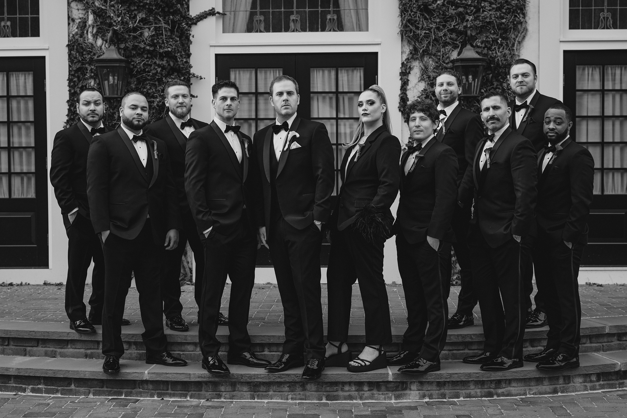 groom stands with groomsmen in suits outside David's Country Inn