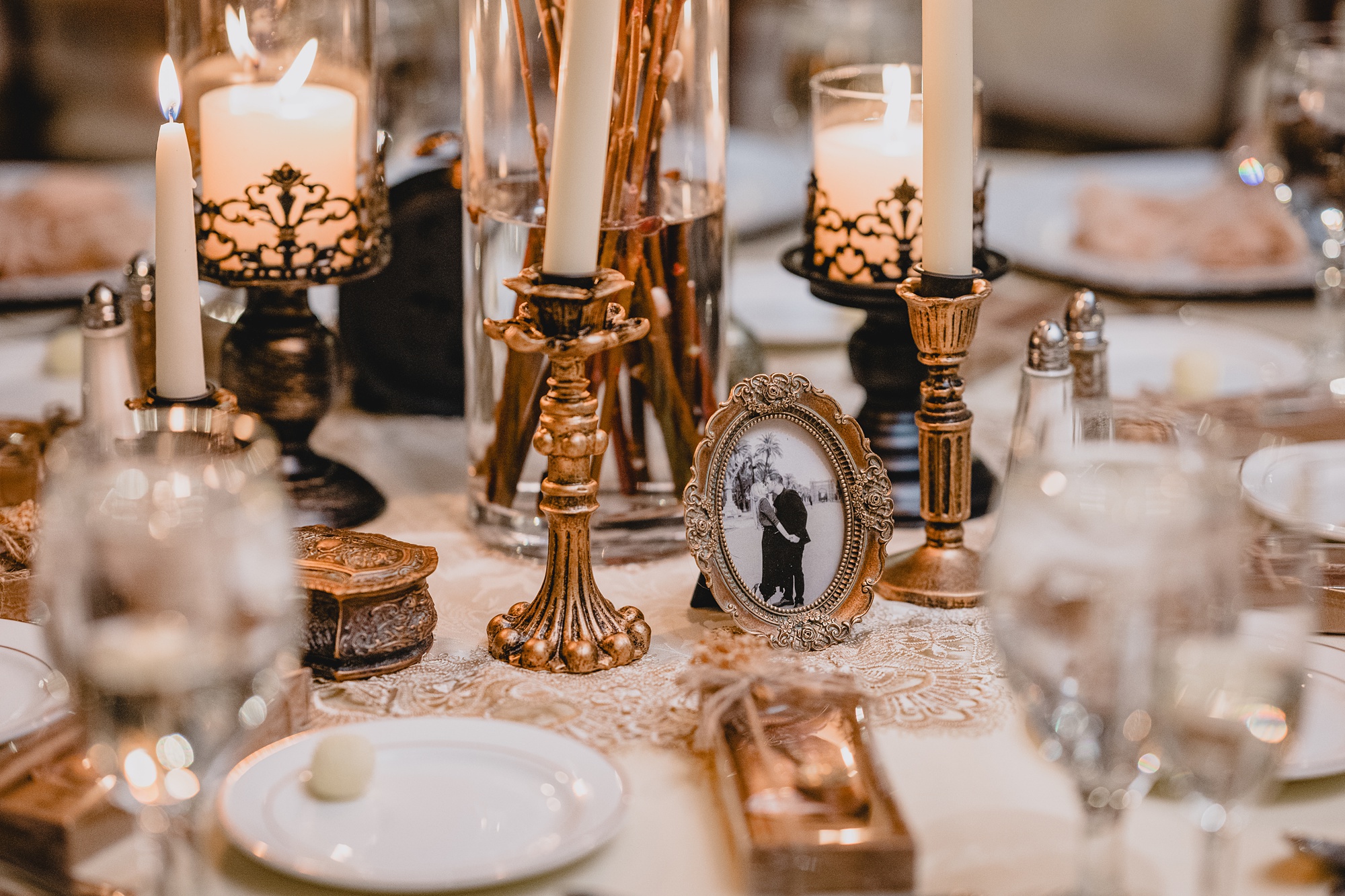 gold details on table with candles and small photo frames at David's Country Inn