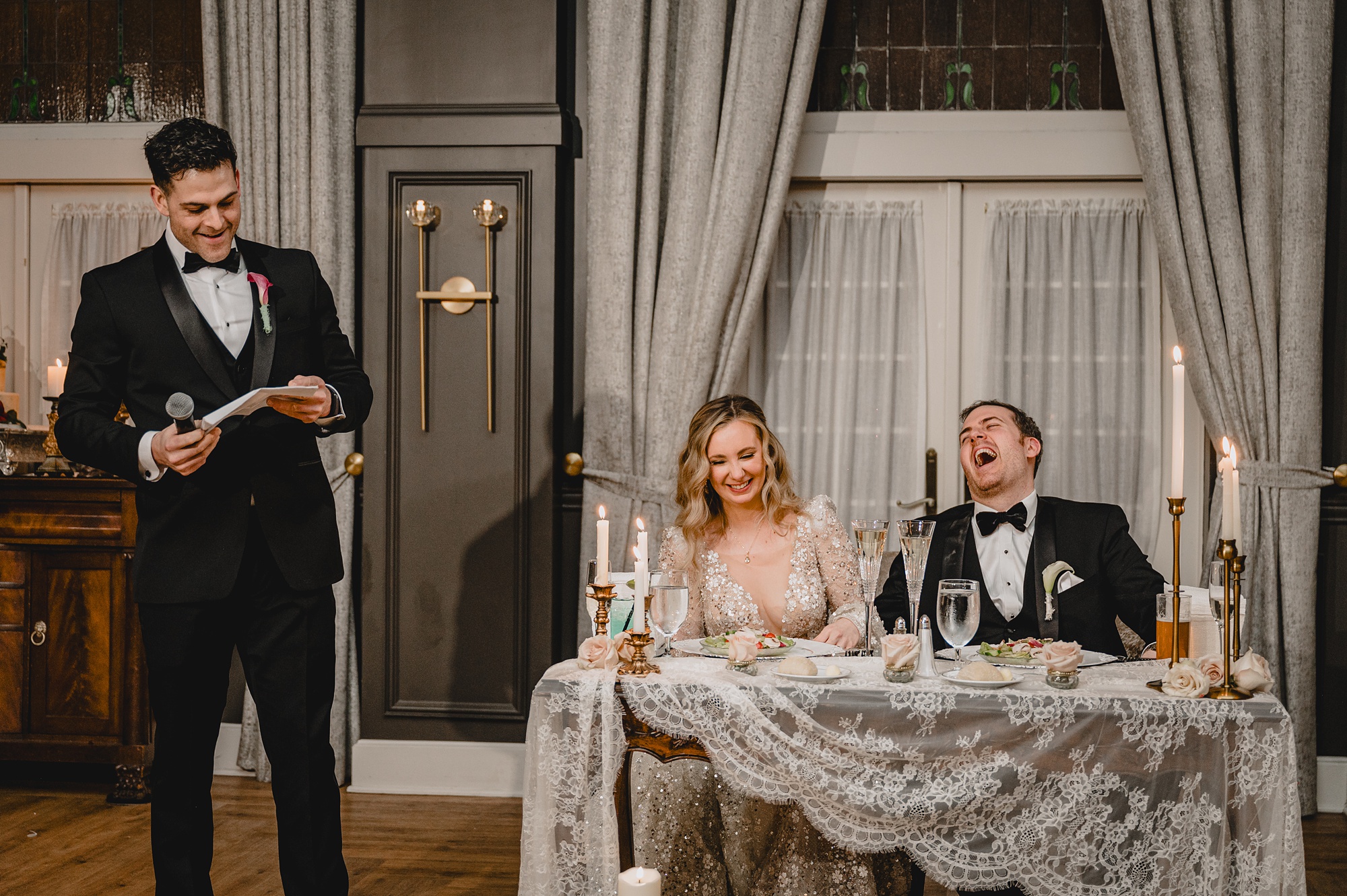 bride and groom laugh listening to speeches during NJ wedding reception