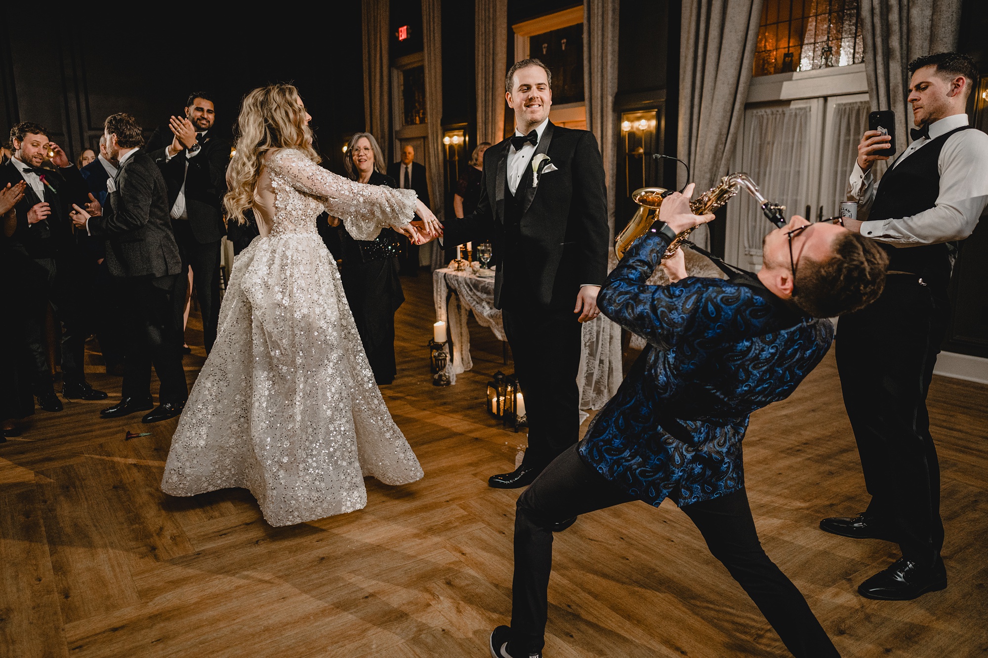 live musician performs on dance floor next to bride and groom