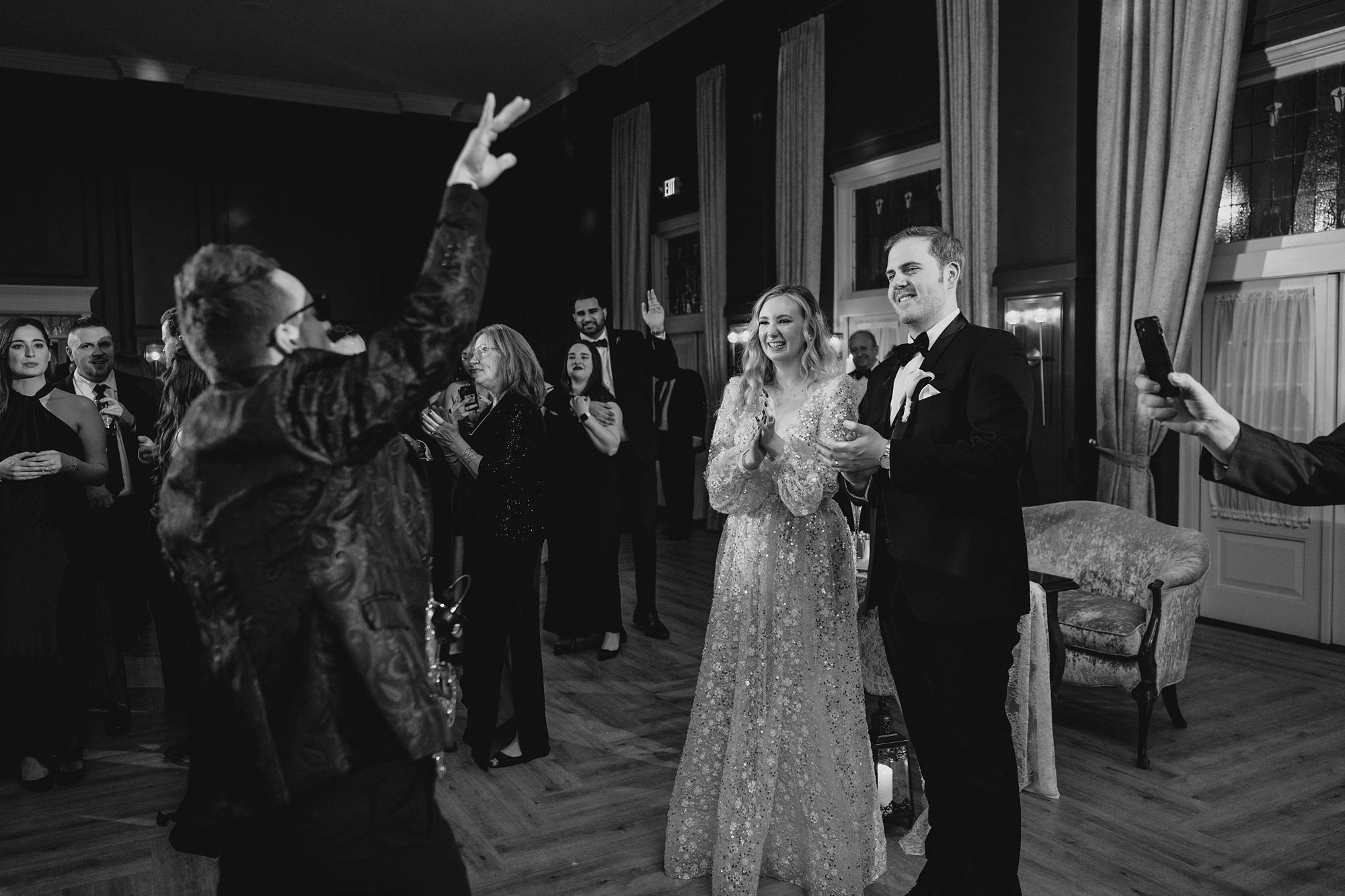 saxophone player performs in front of bride and groom on the dance floor