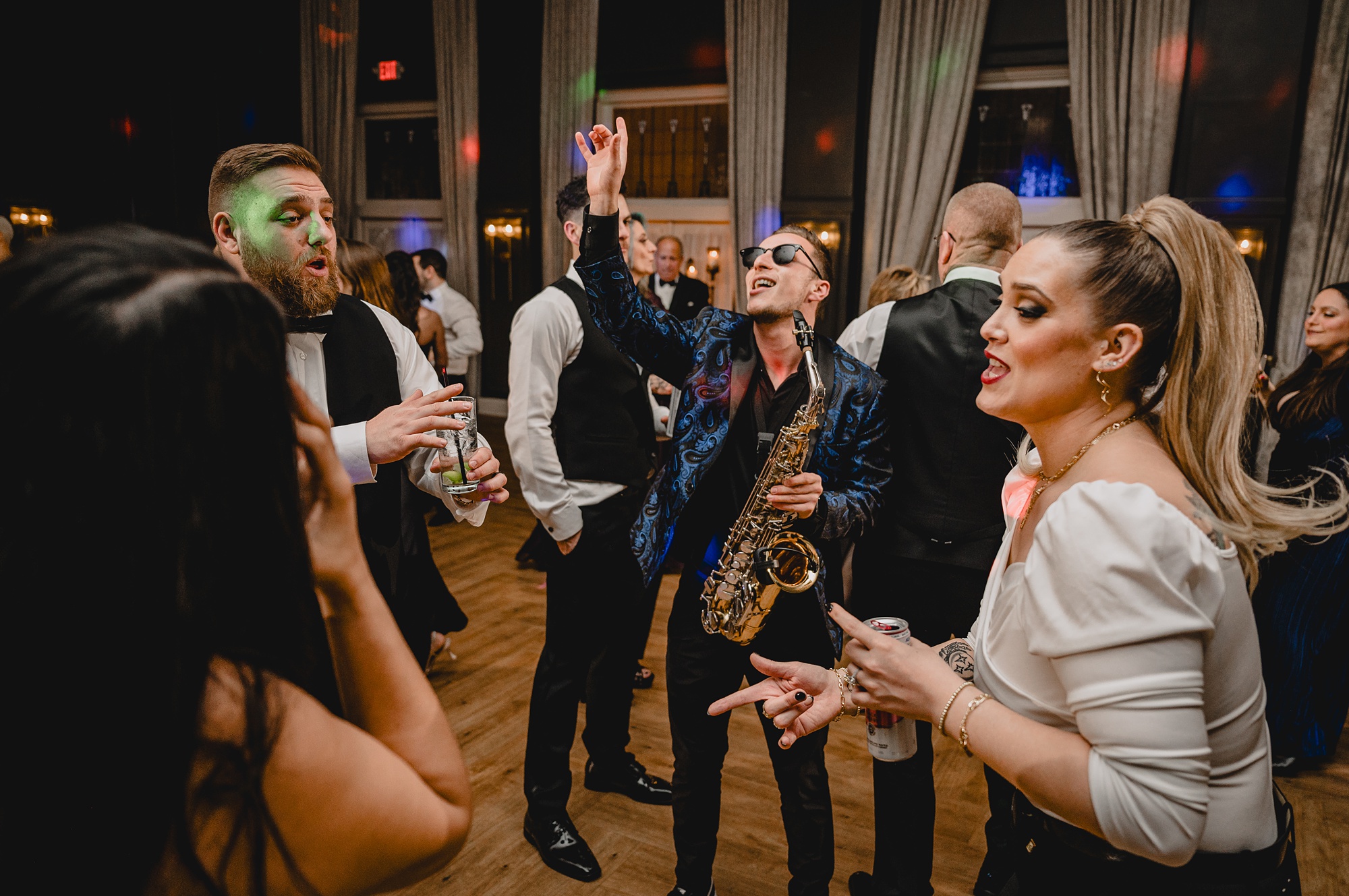 saxophone player performs in front of bride and groom on the dance floor
