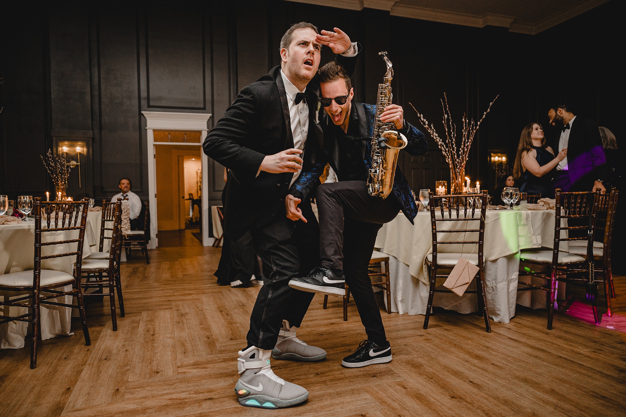 saxophone player performs in front of bride and groom on the dance floor