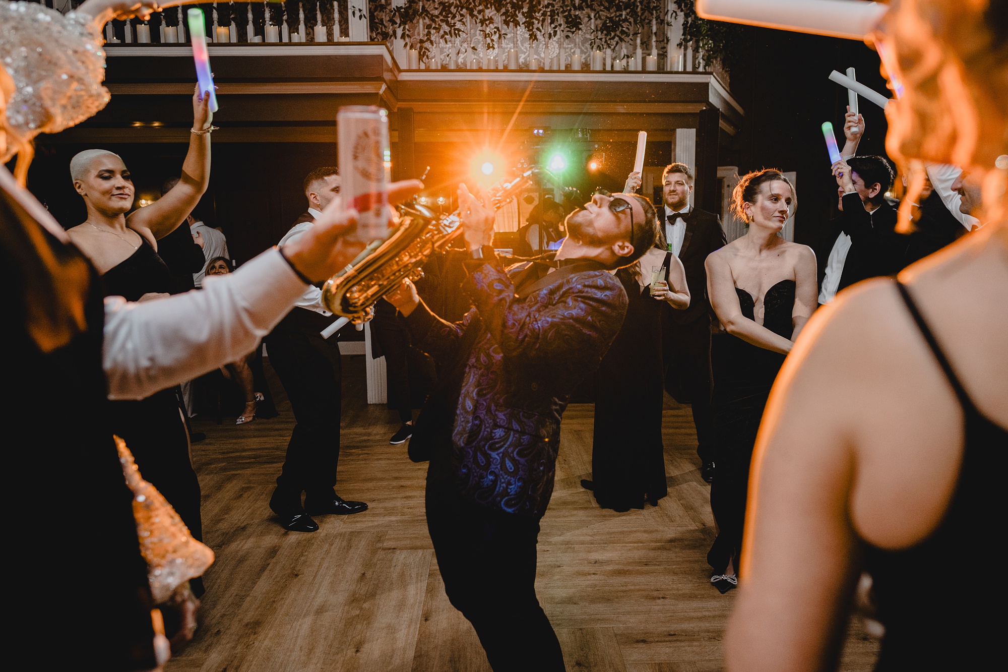 saxophone player performs in front of bride and groom on the dance floor