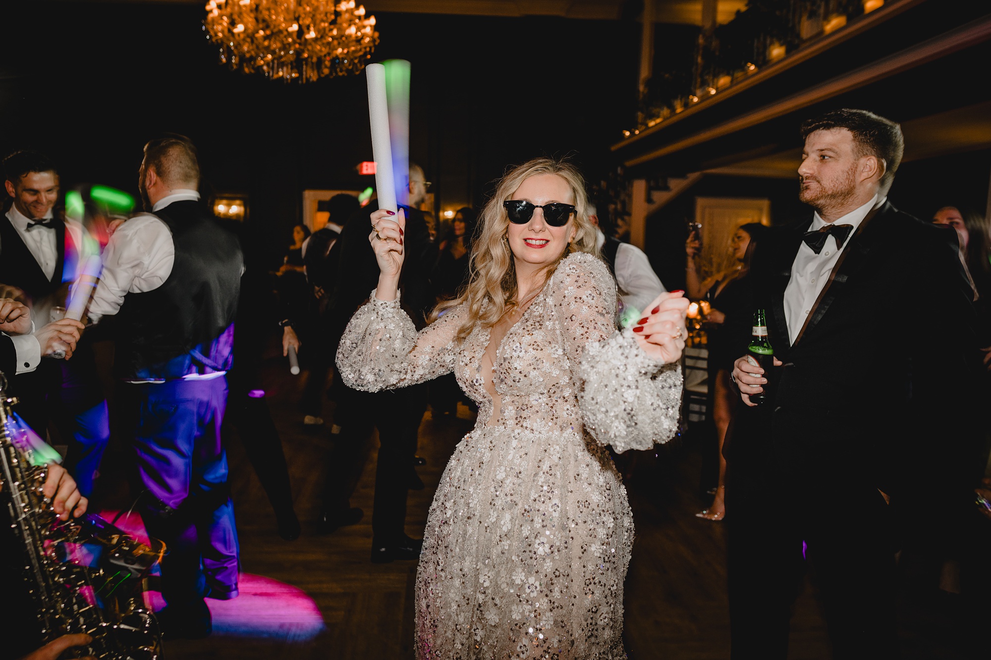 bride dances with glow sticks and sunglasses on during NJ wedding reception