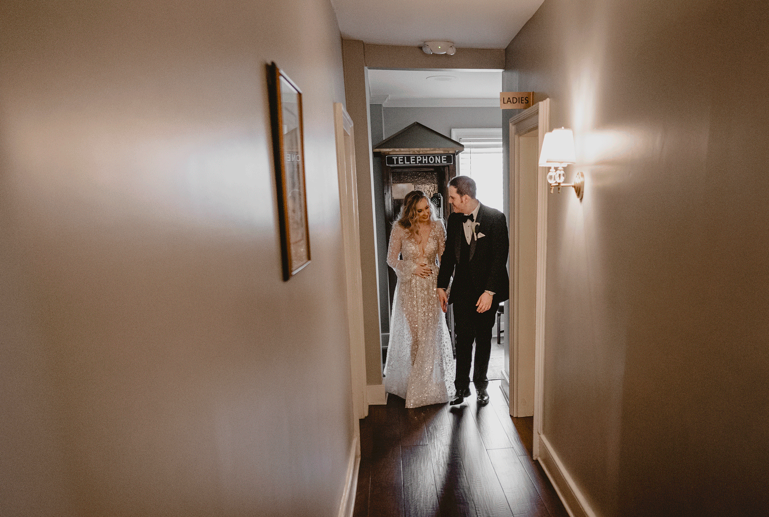couple holds hands walking down hallway at David's Country Inn