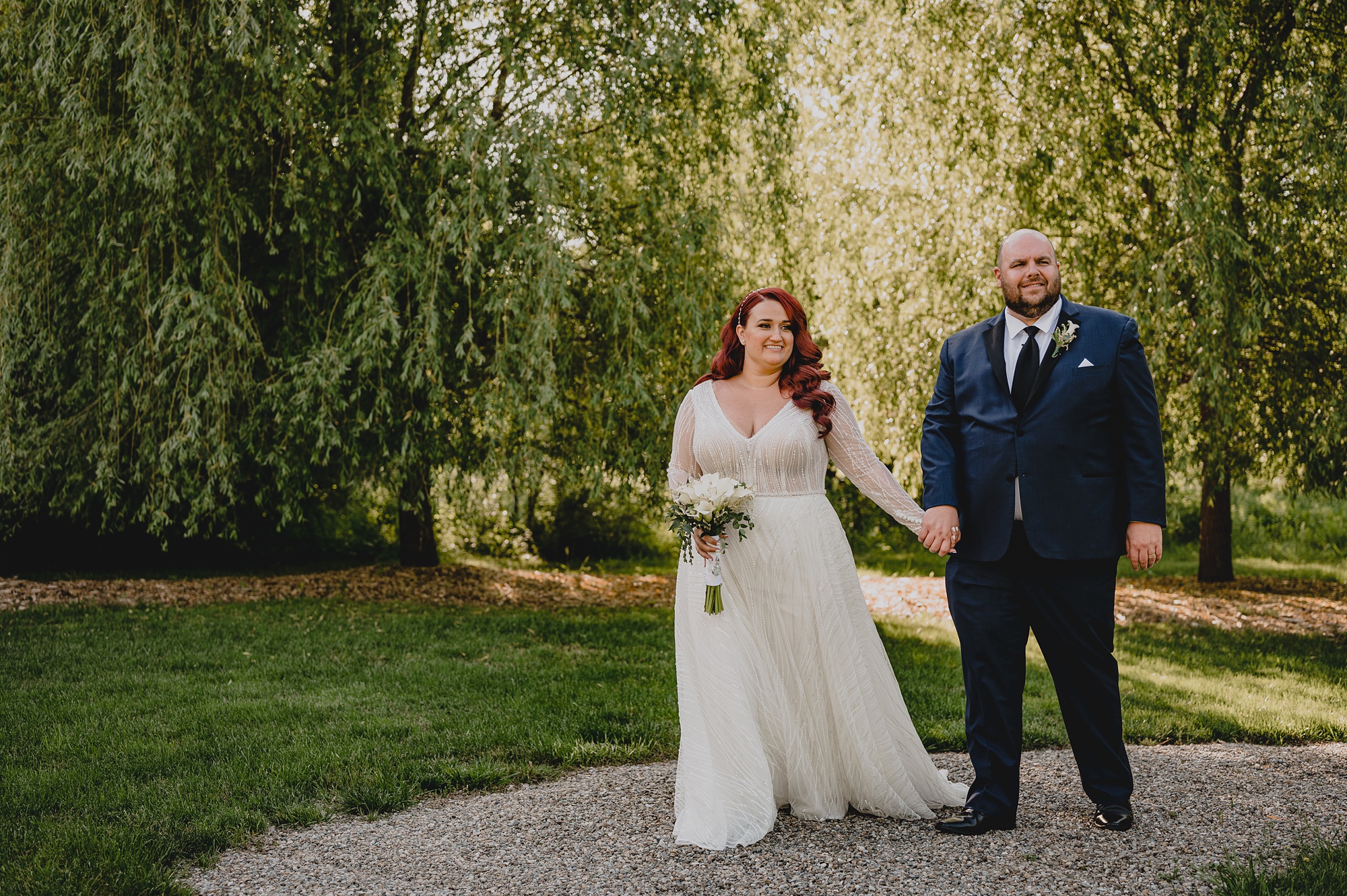 bride and groom hold hands walking on pathway at NJ wedding venue