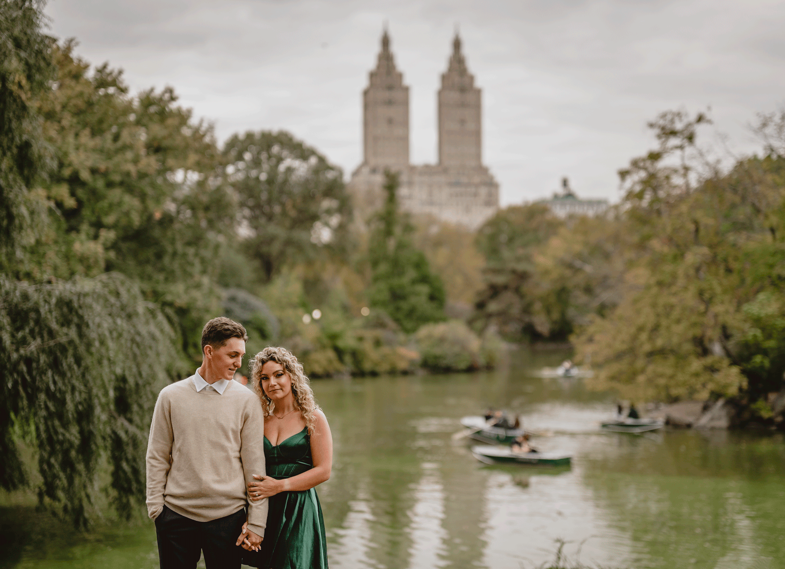woman leans on man's shoulder in front of pond in Central Park