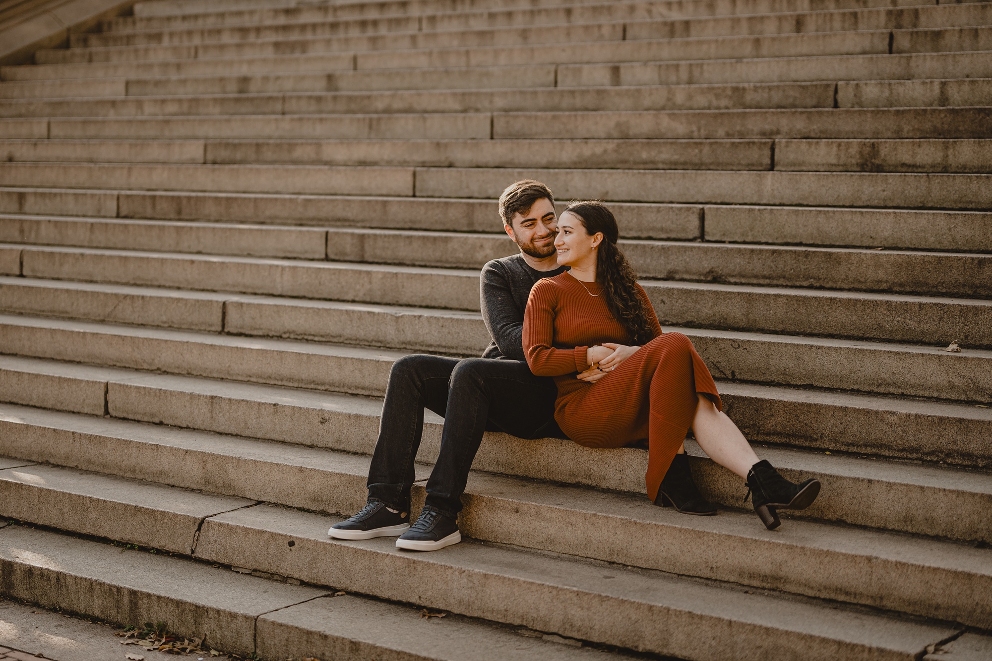 engaged couple sits on steps in Central Park 