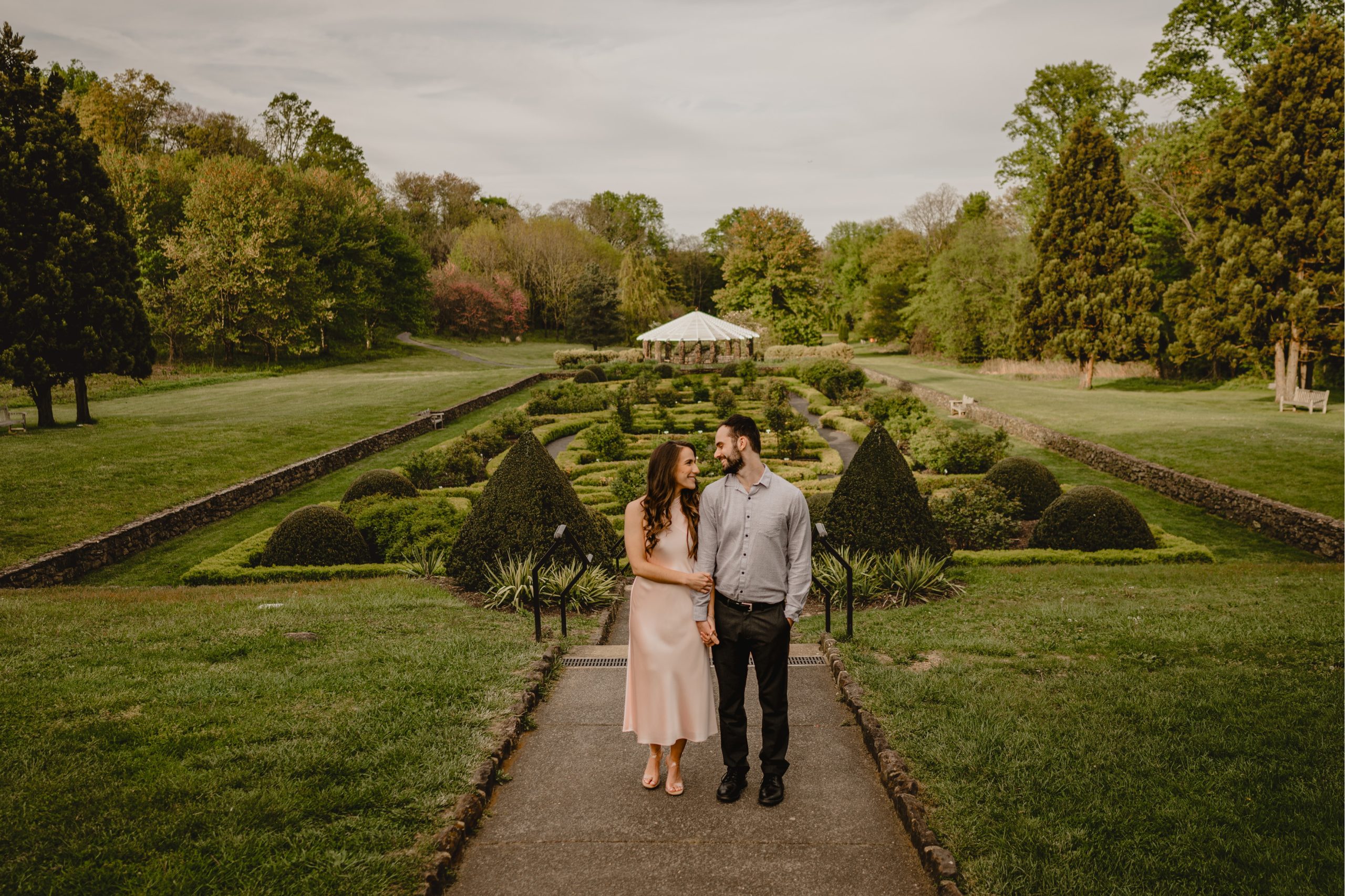 engaged couple stands hugging in gardens in New Jersey 