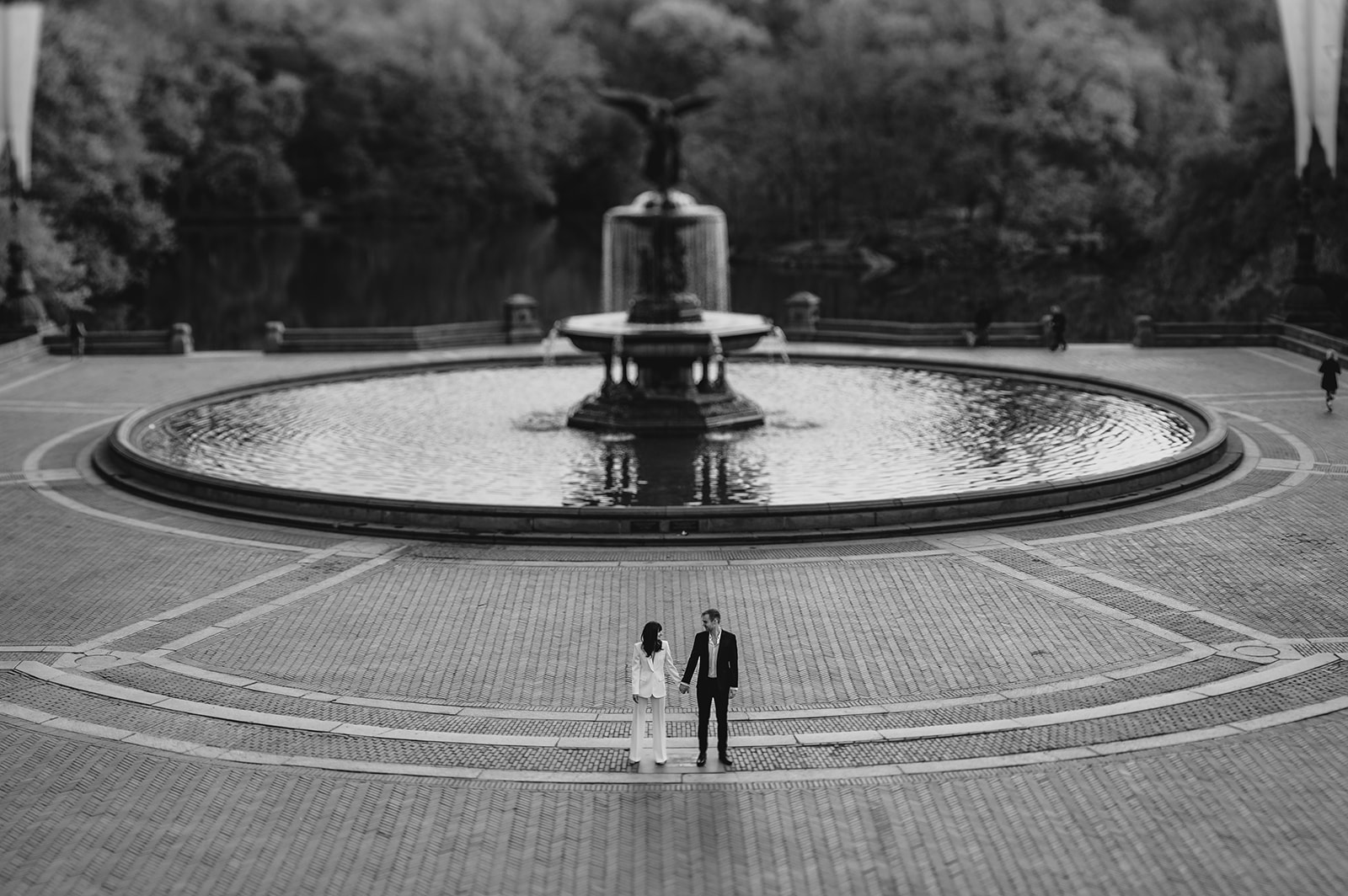 man and woman hold hands in front of Bethesda Fountain in Central Park