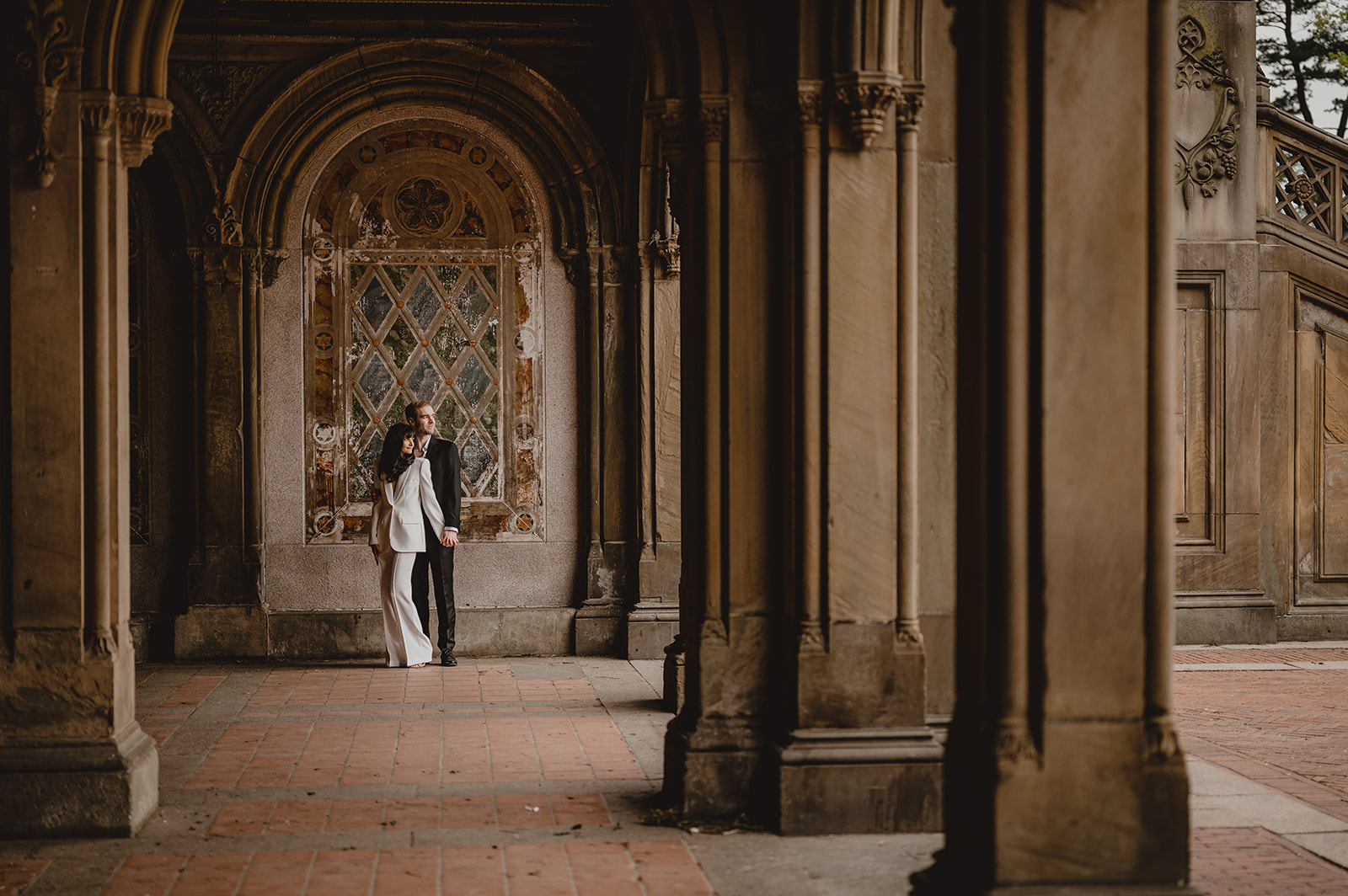 man and woman hug inside Bethesda terrace in Central Park