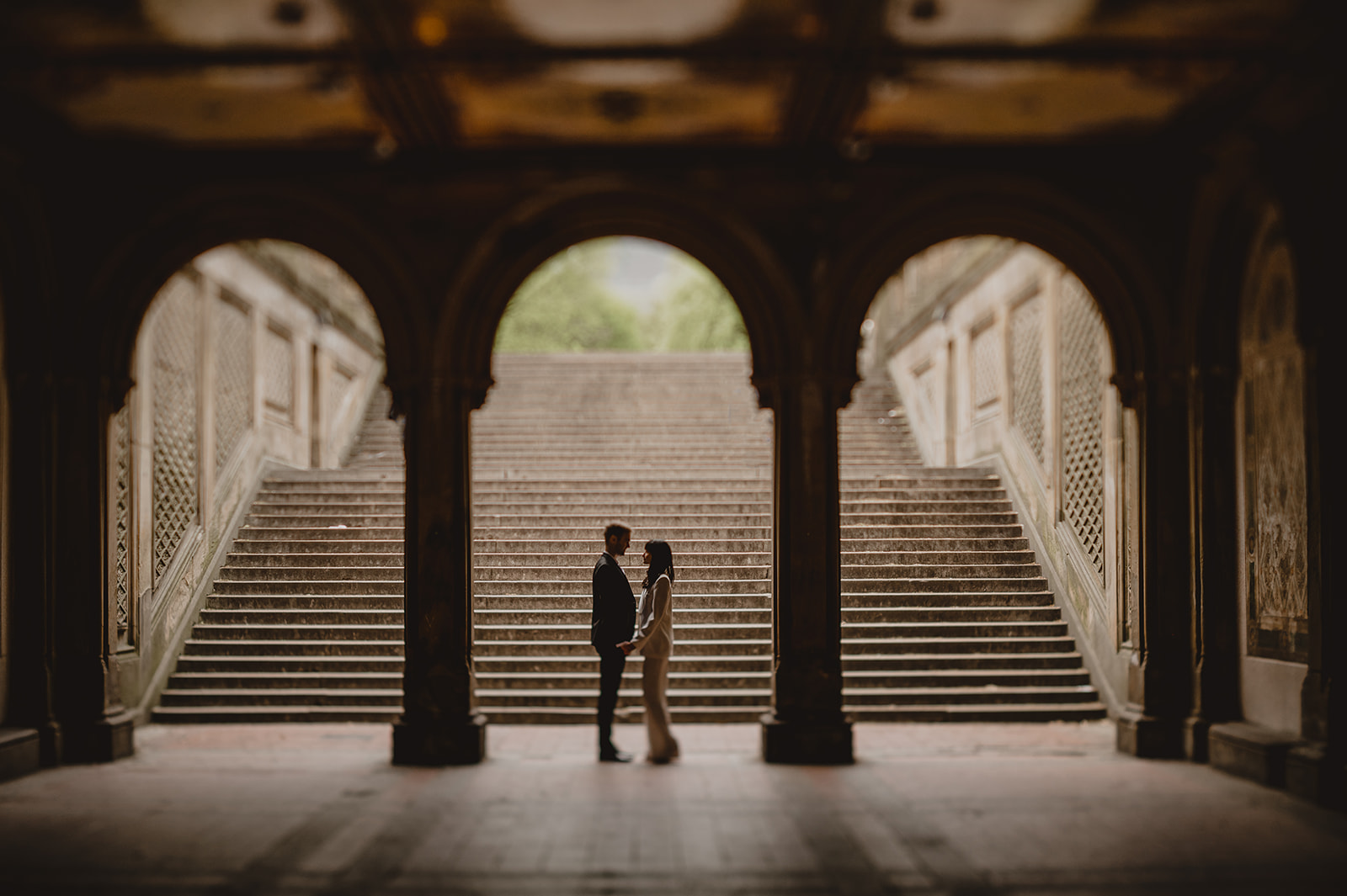 couple look at each other under archway in New York City park