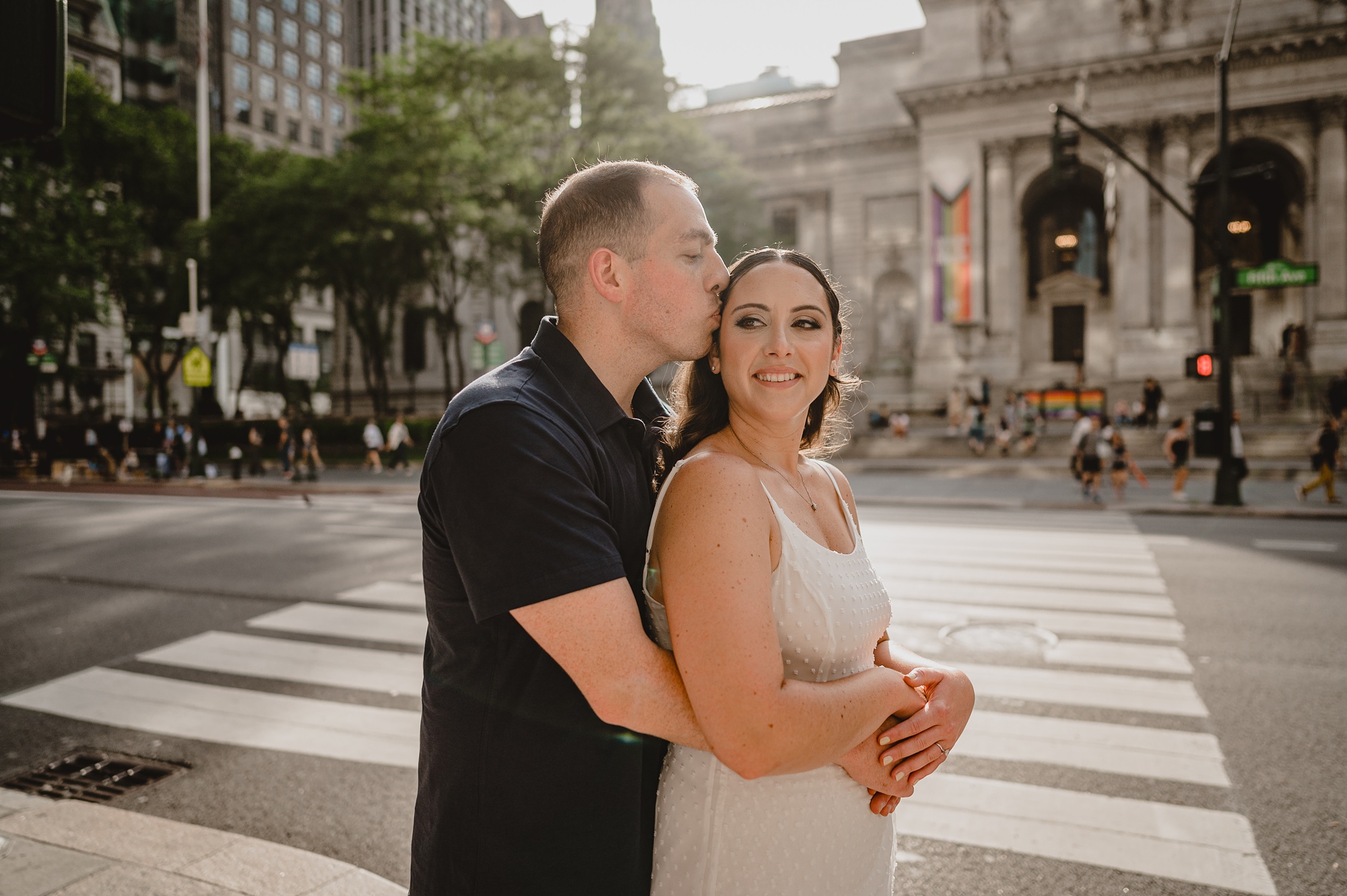 man hugs woman from behind outside the New York Public Library
